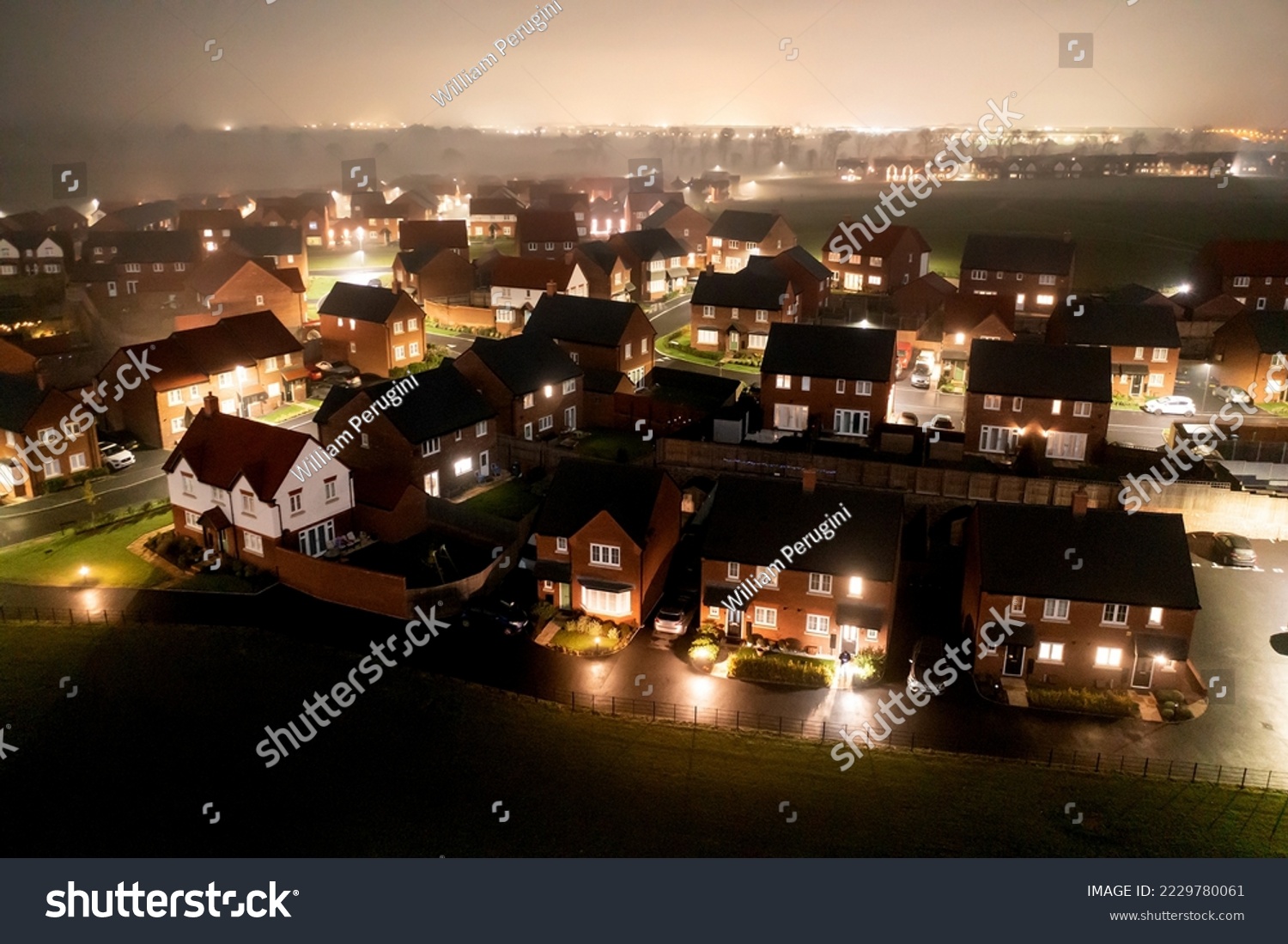 Aerial view of houses in England at night  - Drone view of a new estate with typical British houses and fog mist - Real estate and buildings concepts in UK #2229780061
