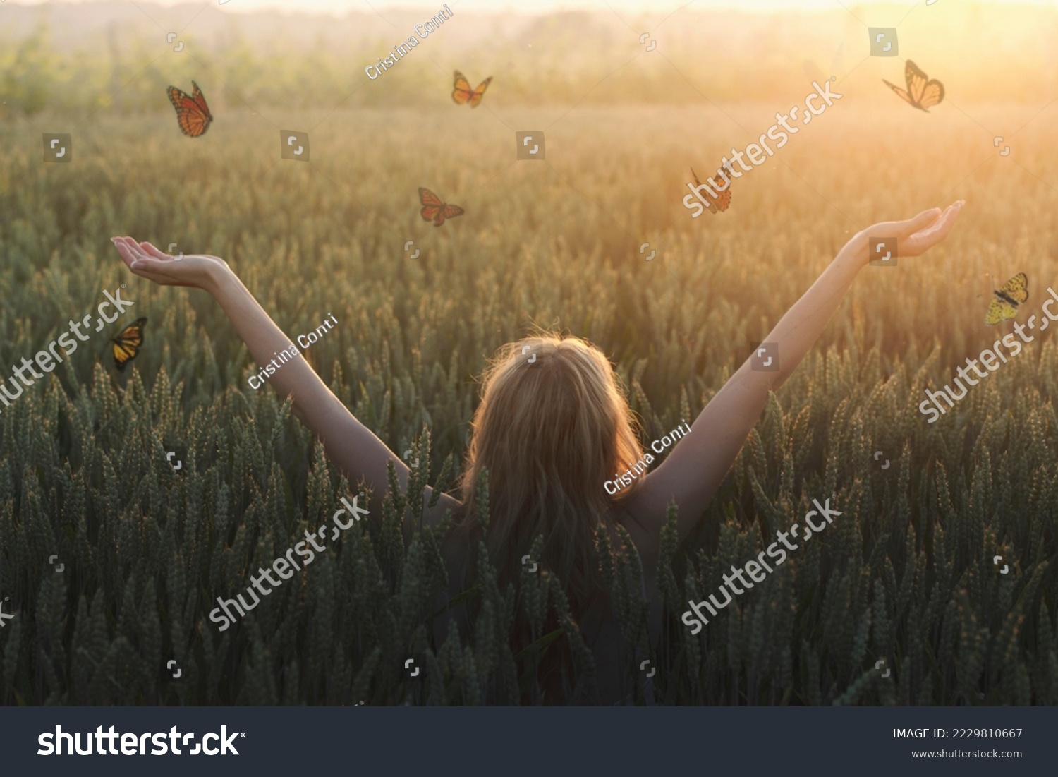 surreal encounter between a woman and free butterflies flying in the middle of nature #2229810667