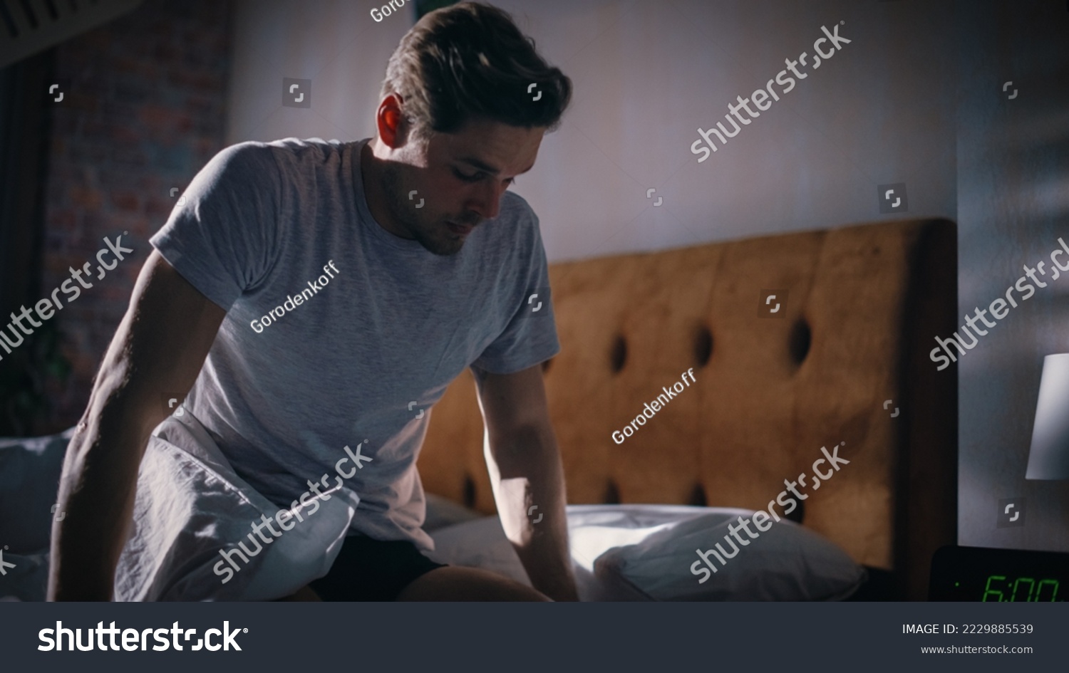Man Wakes Up, Turns off Alarm Clock with Frustration, after Sleepless Insomniac Night. Early Rising Stressed Man Ready to Face Day of Problem Solving. He is Tired, Upset #2229885539