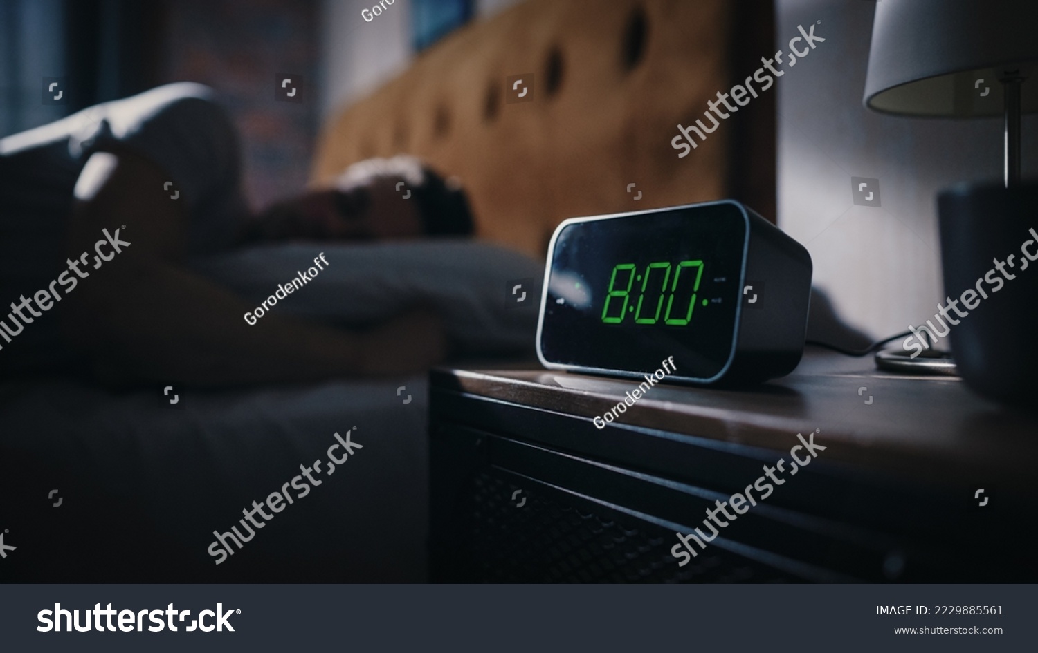 Man Wakes Up and Turns off Alarm Clock. Early Rising Productive Man Ready Start a Day of New Business Opportunities. Focus on the Clock Showing Eight O'Clock on Bedside Nightstand bedroom Apartment #2229885561