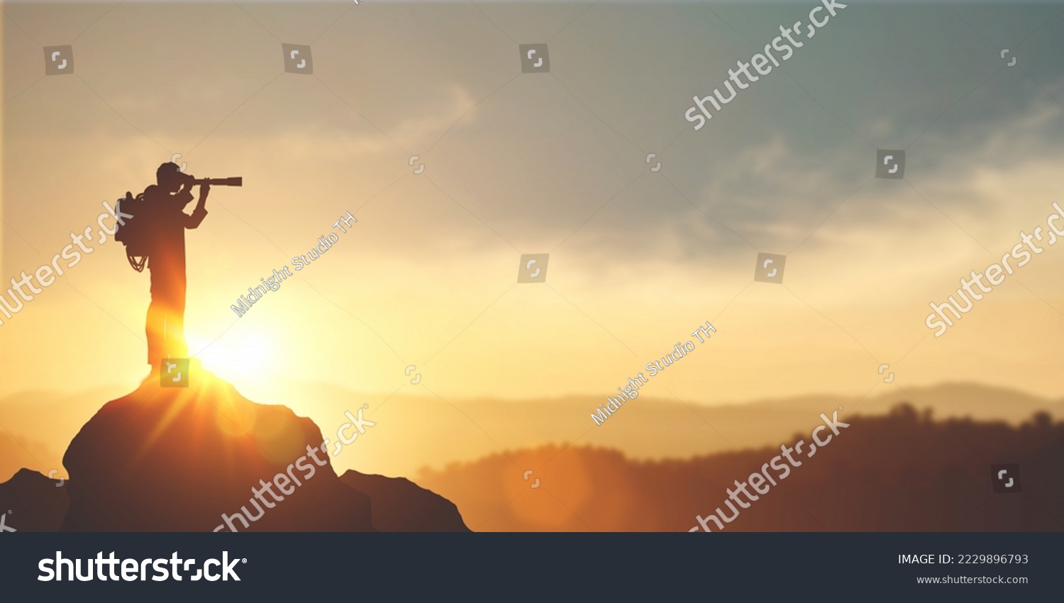 vision for success ideas. businessman's perspective for future planning. Silhouette of man holding binoculars on mountain peak against bright sunlight sky background. #2229896793