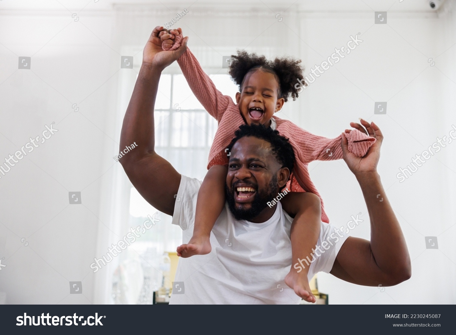 enjoy happy love black family african american father carrying daughter little african girl child smiling in the white living room at home. Happy black African American father day concept. #2230245087