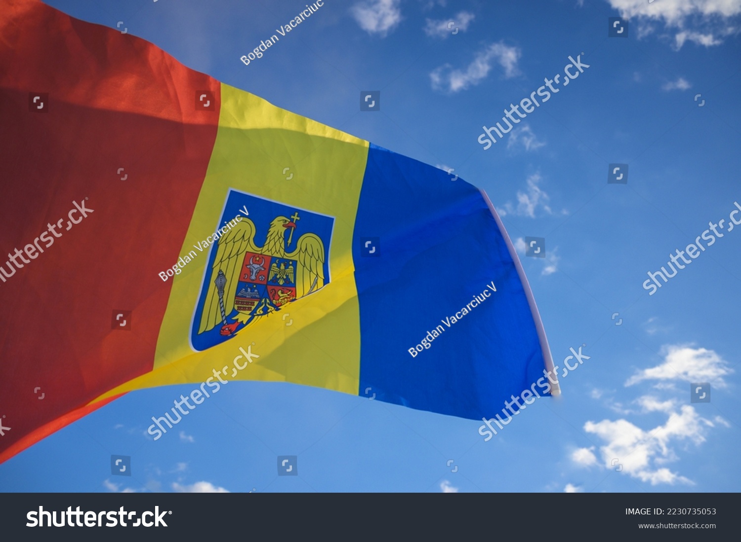 The Romanian flag fluttered in the wind with the blue sky in the background. December, 01- National Day of Romania. #2230735053