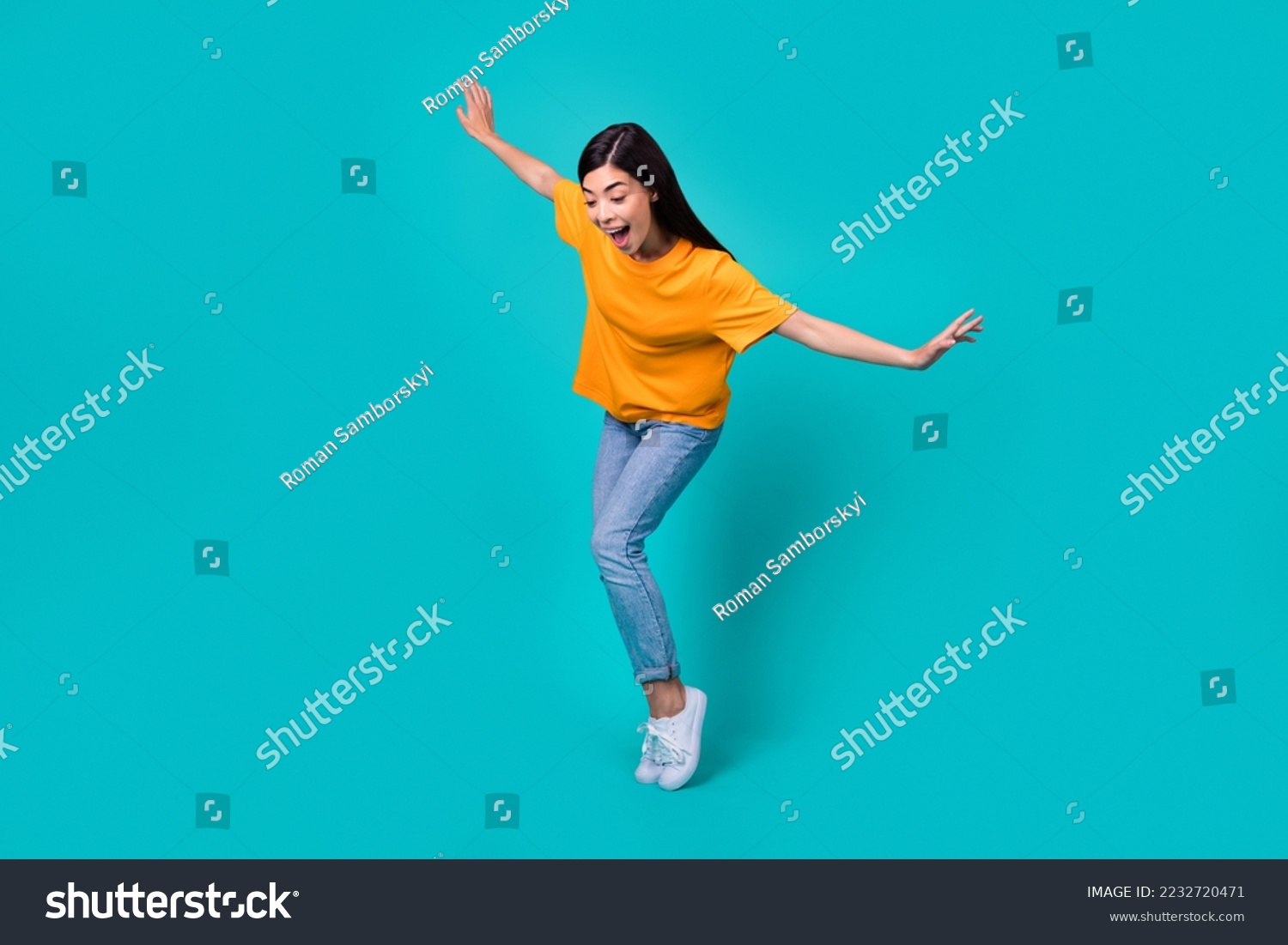 Full body photo of funky brunette lady dance look down wear t-shirt jeans boots isolated on teal color background #2232720471