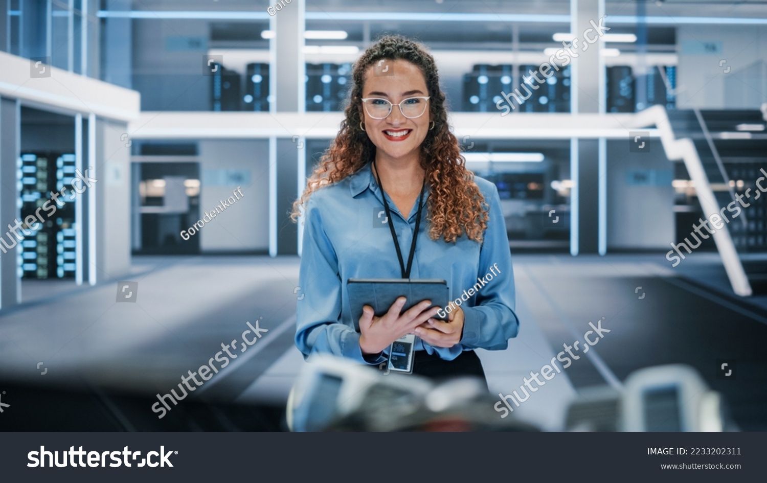 Portrait of a Beautiful Latin Female Wearing Smart Corporate Shirt and Glasses, Looking at Camera and Smiling. Businesswoman, Information Technology Manager, Robotics Engineering Specialist. #2233202311