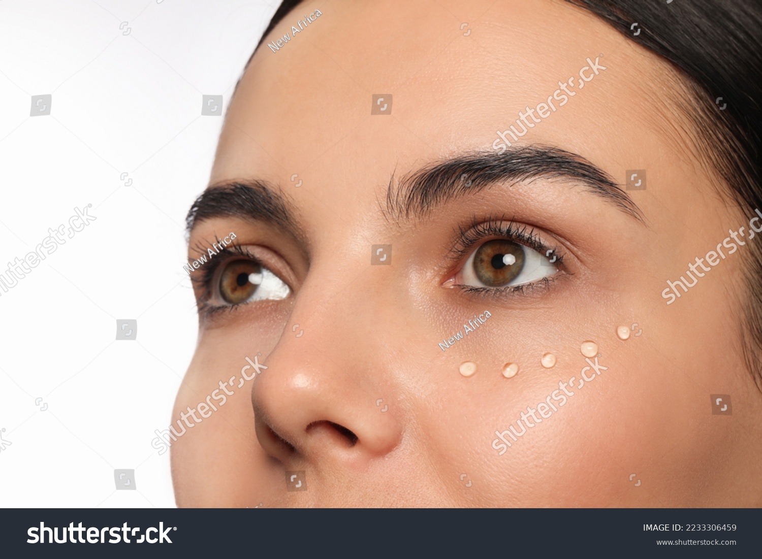 Closeup view of young woman with gel on skin under eye against white background #2233306459