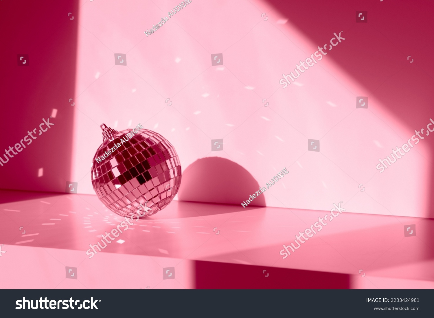 Magenta Disco ball in sunlight with reflections on white background. Geometric shadows #2233424981