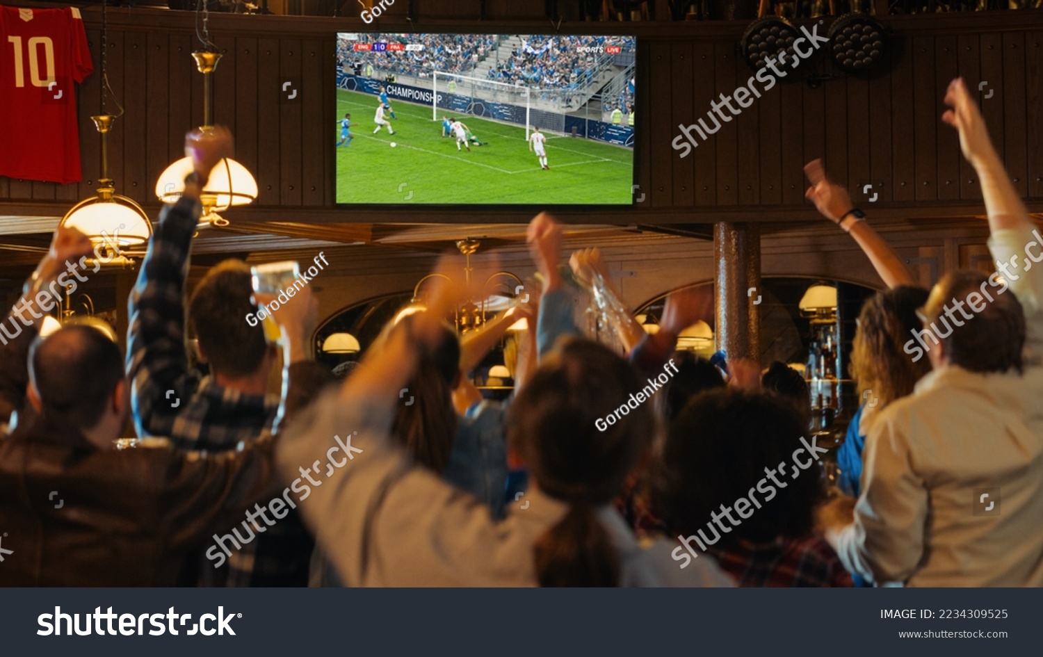 Group of Soccer Fans Cheering, Screaming, Raising Hands and Jumping During a Football Game Live Broadcast in a Sports Pub. Player in Blue Shirt Scores a Goal and Friends Celebrate. Slow Motion Footage #2234309525