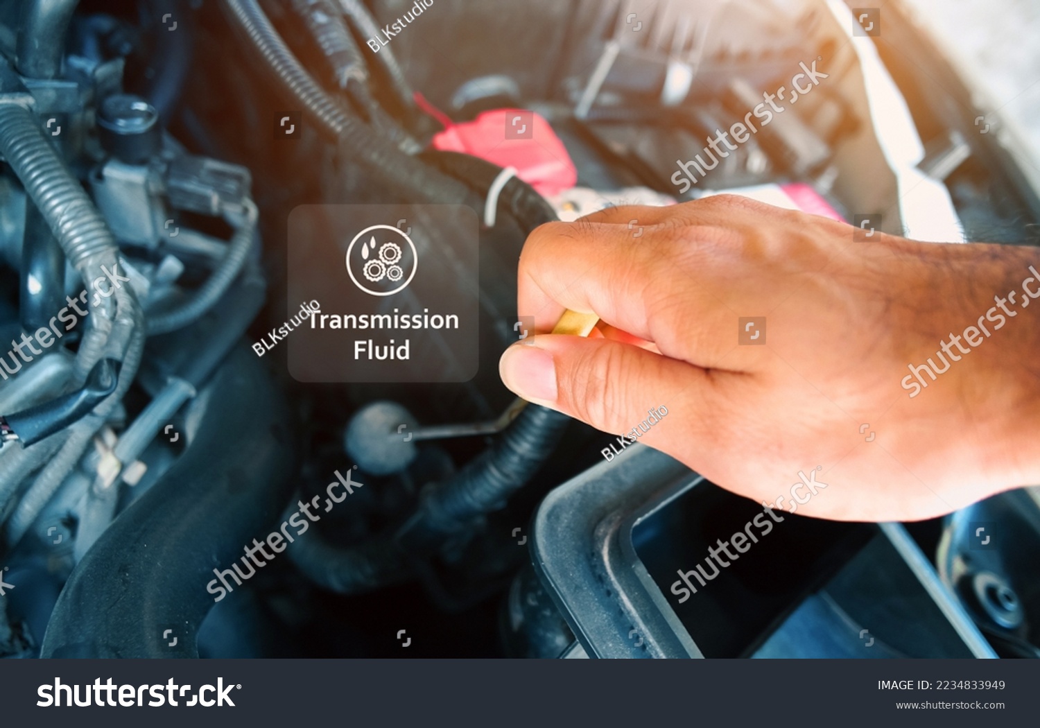 Check the transmission fluid level and gear oil deterioration by a mechanic with transparent gear oil warning symbols on center, auto maintenance service concept #2234833949