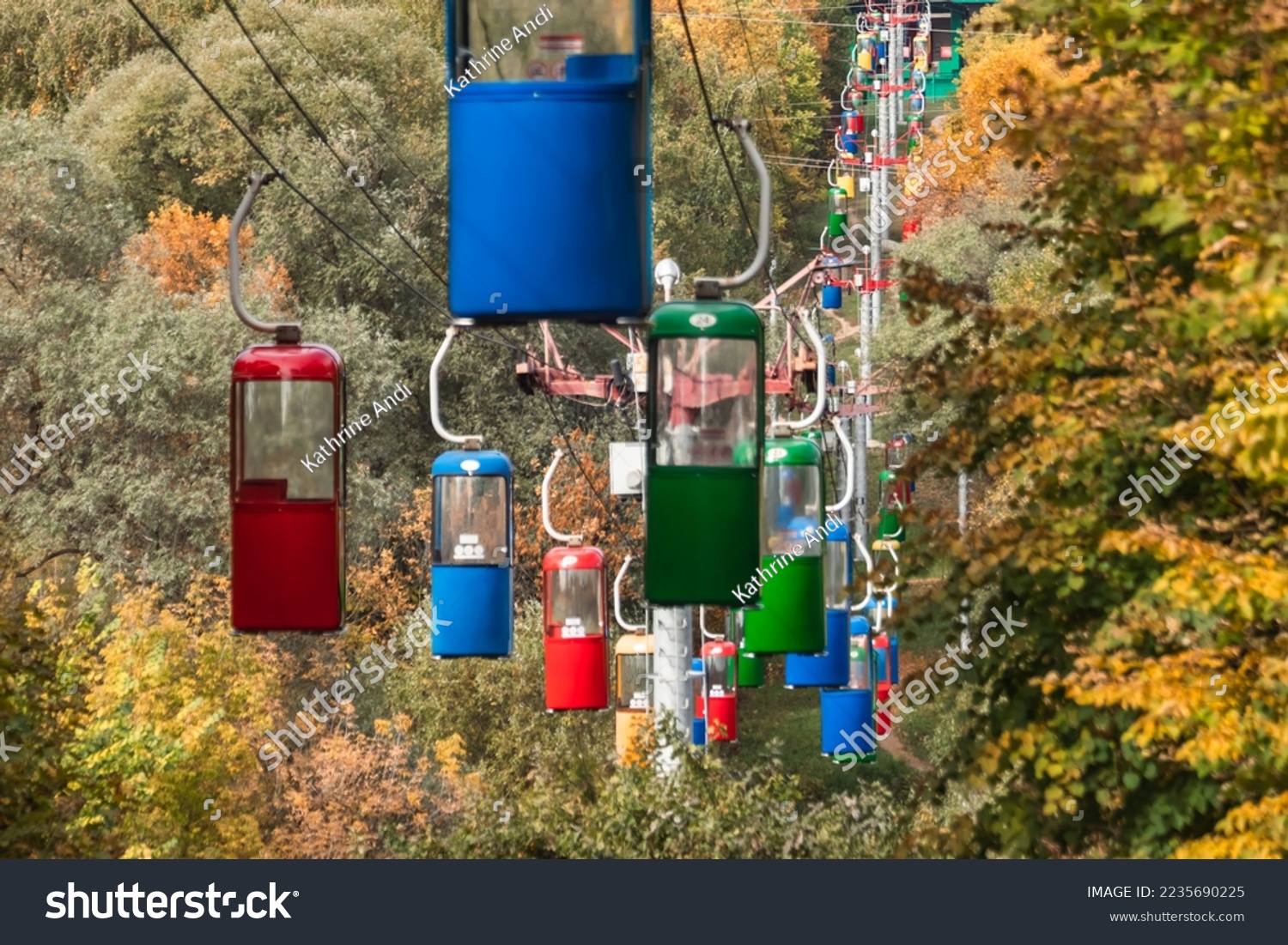 Colorful cableway cabins in autumn greenery in Kharkiv city recreation park #2235690225