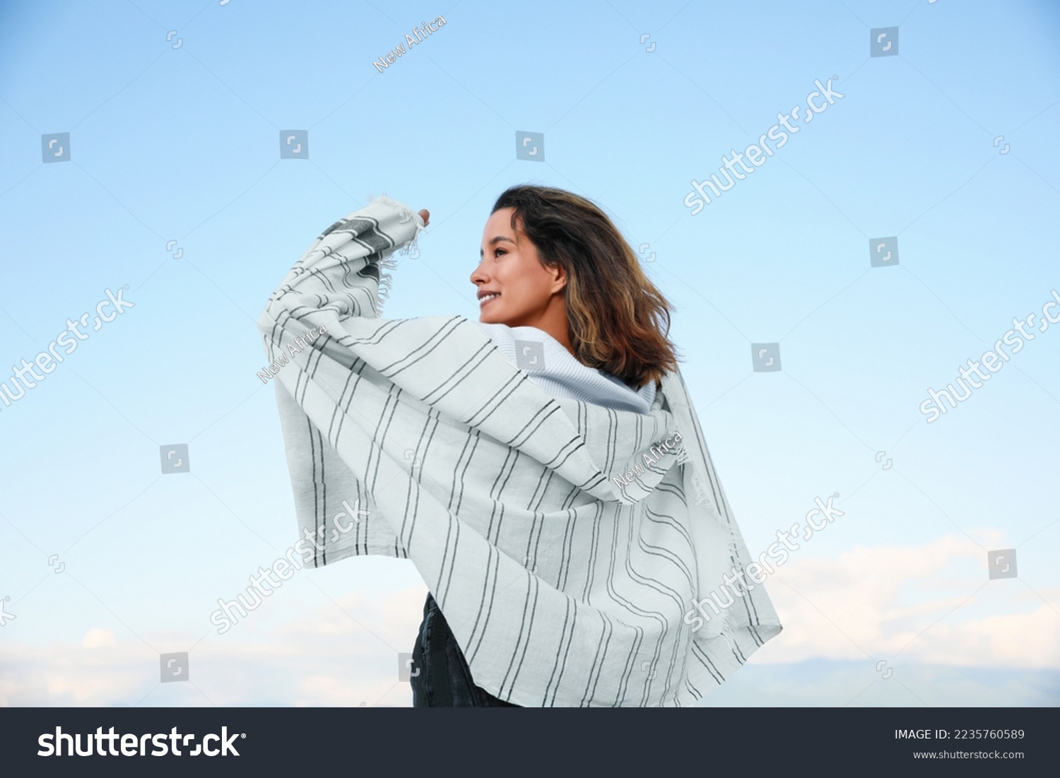 Portrait of beautiful young woman against blue sky #2235760589
