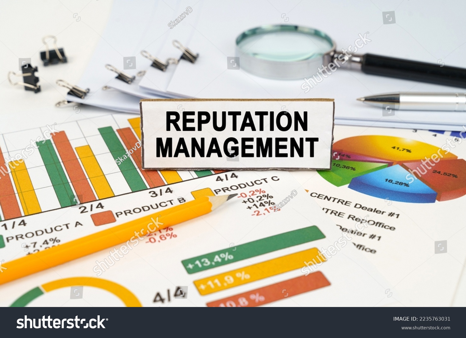 Business concept. On the business charts lies a magnifying glass, a pen and a sign with the inscription - Reputation Management #2235763031