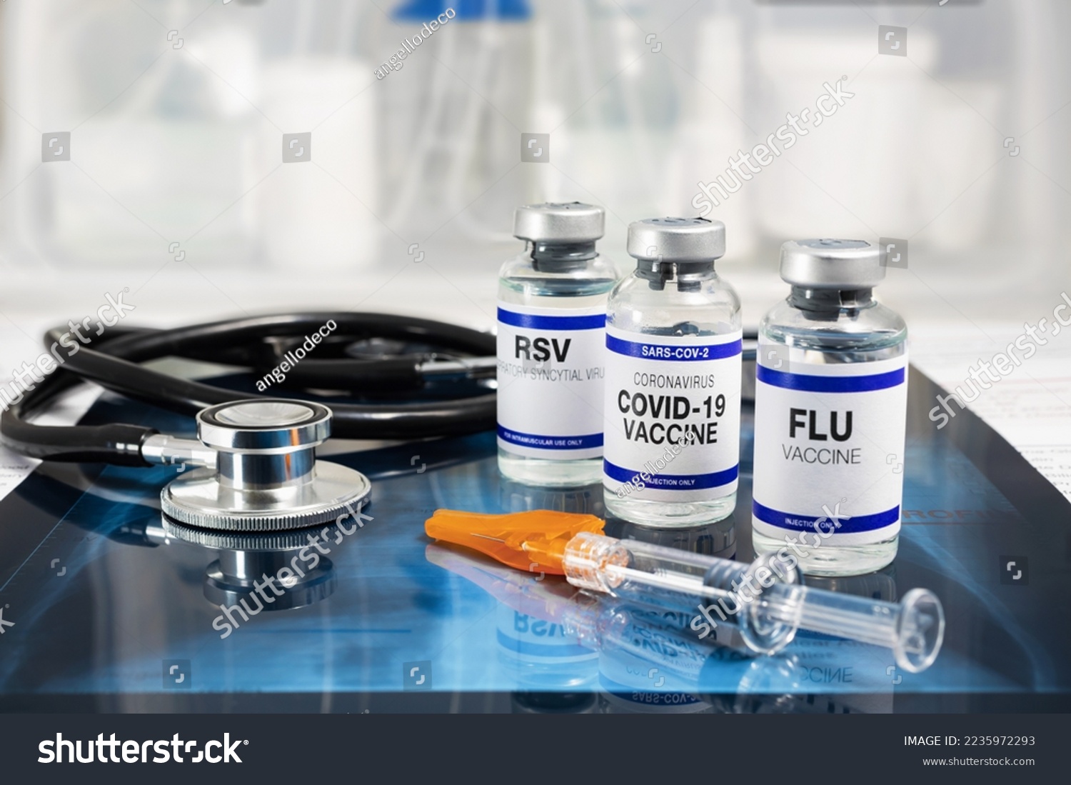 Bottles of vaccine for Influenza Virus, Respiratory Syncytial virus and Covid-19 for vaccination. Flu, RSV and Sars-cov-2 Coronavirus vaccine vials over Radiography pulmonar with stethoscope #2235972293