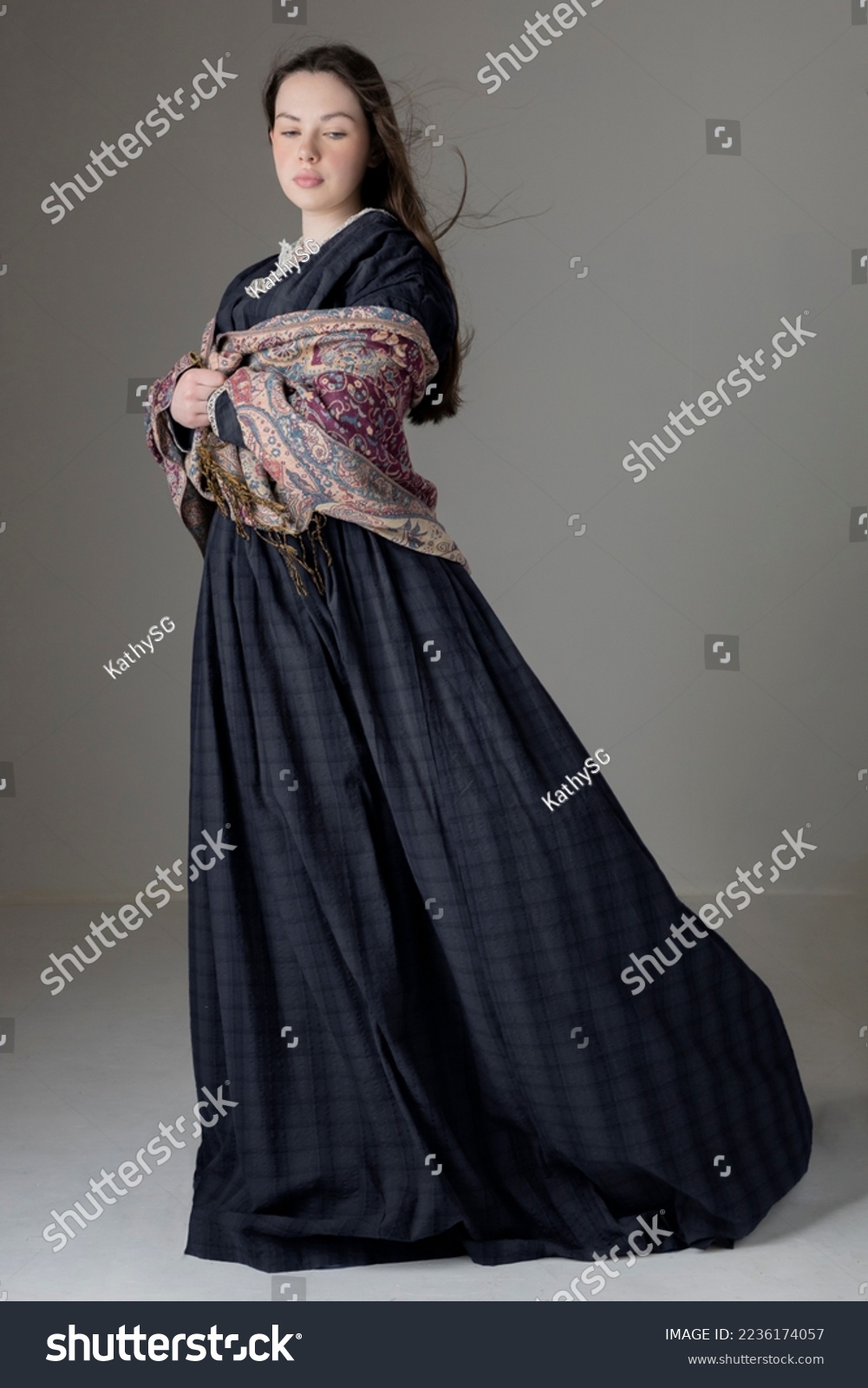 A young Victorian woman wearing a bluegrey cotton dress with a paisley shawl #2236174057