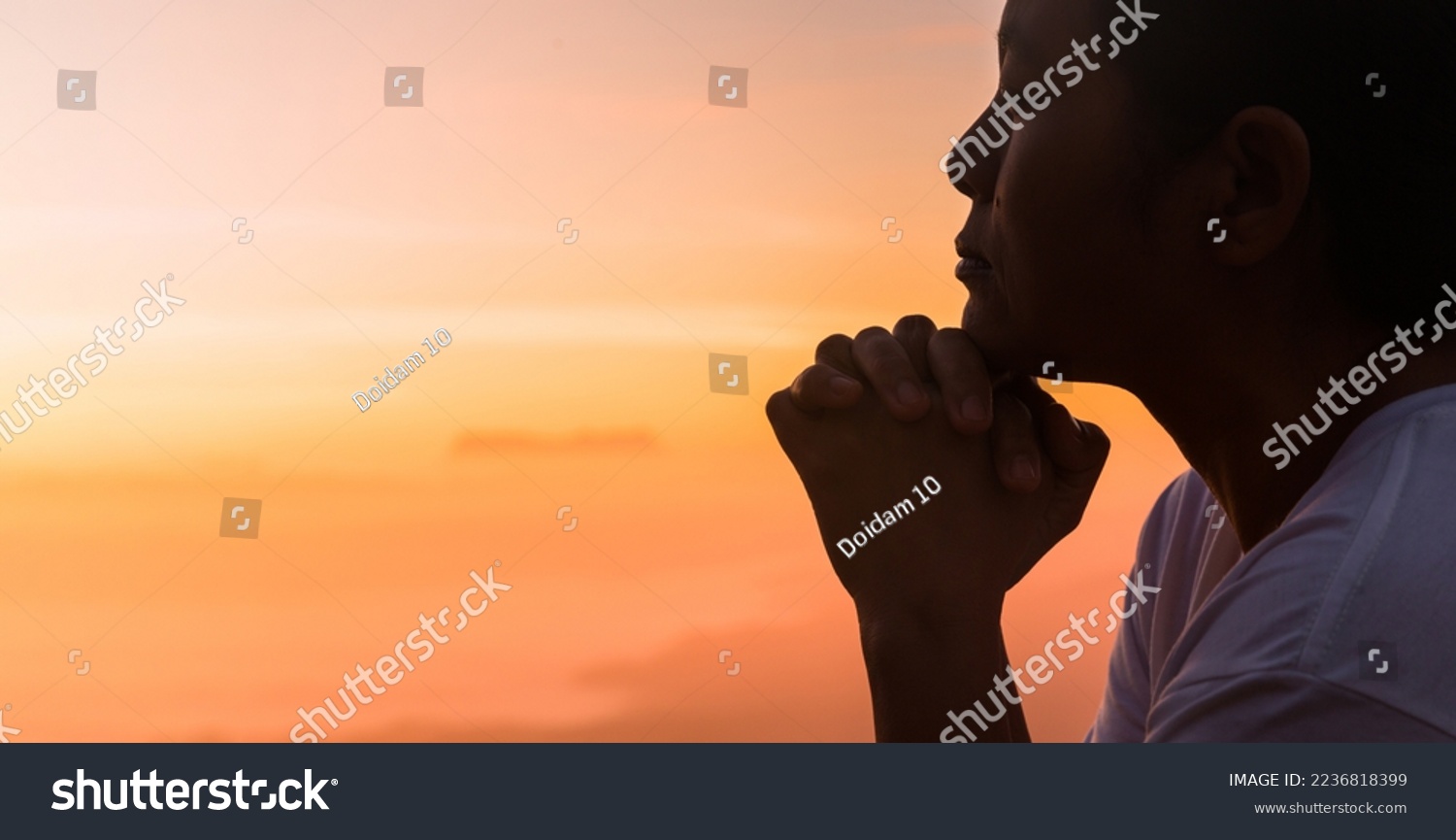 Silhouette of woman hand praying spirituality and religion, female worship to god. Christianity religion concept. Religious people are humble to God. Christians have hope faith and faith in god. #2236818399