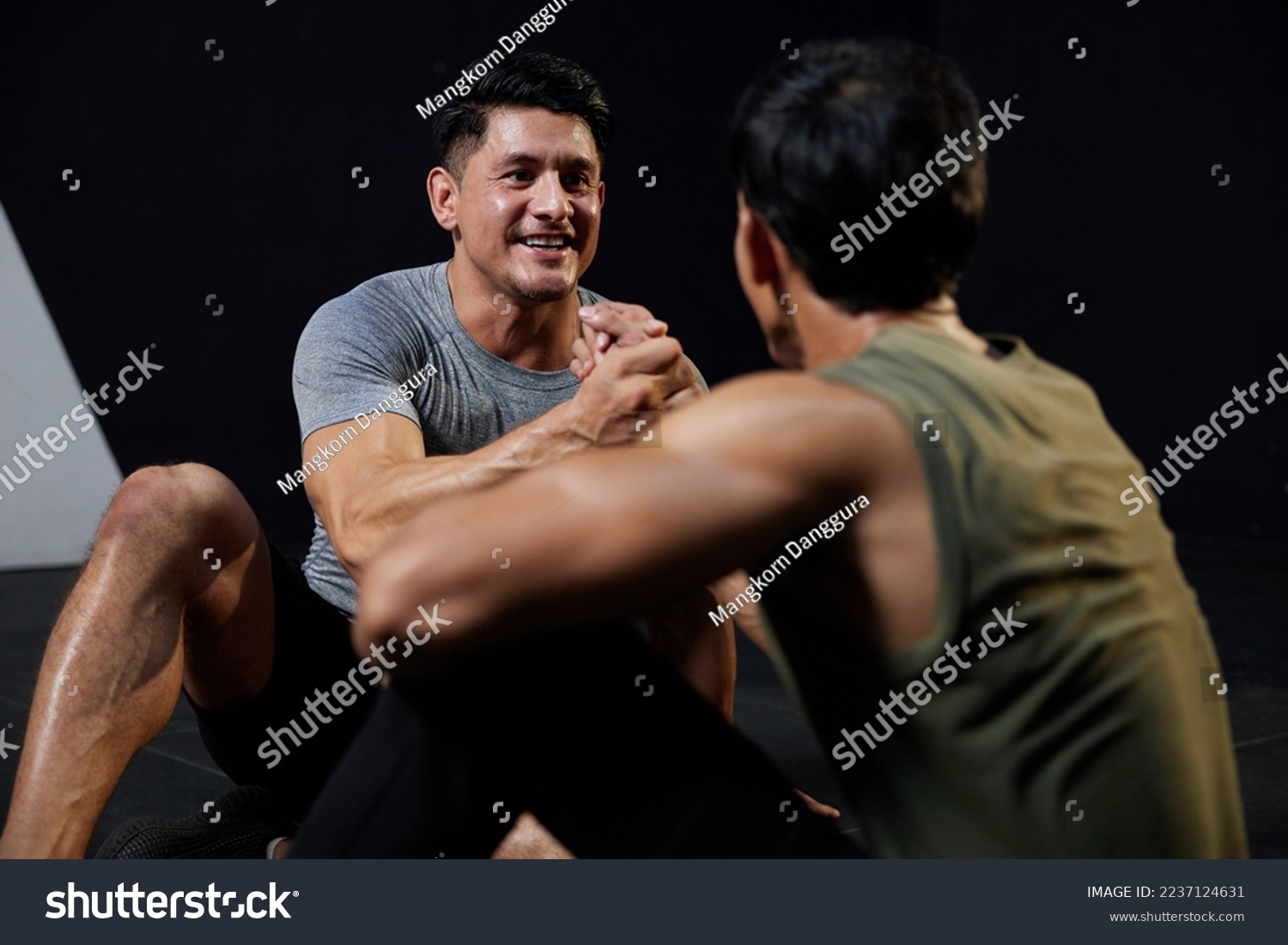 young athletic men meeting in the gym and shaking hands after workout #2237124631
