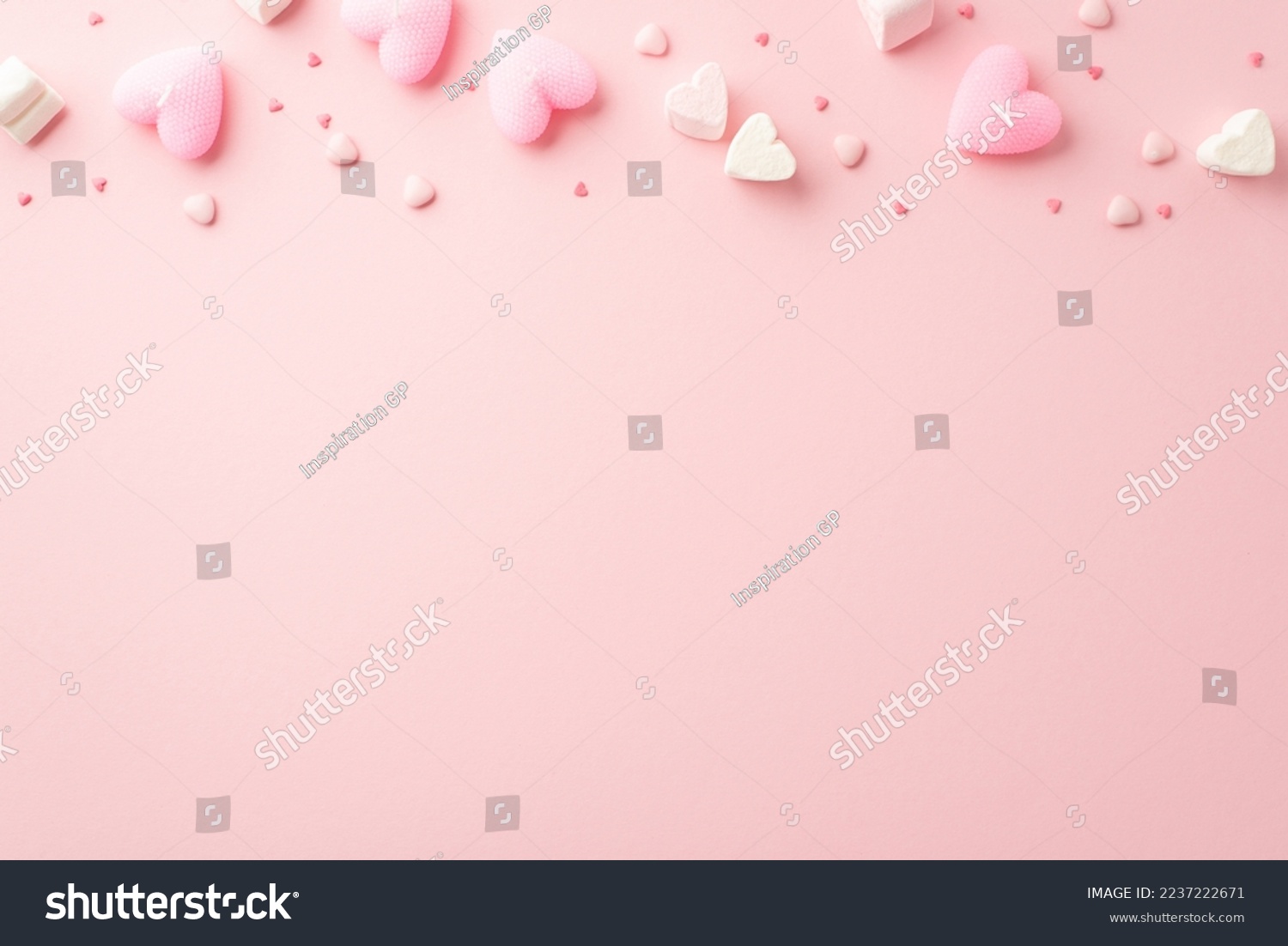 Valentine's Day concept. Top view photo of heart shaped marshmallow candles and sprinkles on isolated light pink background with copyspace #2237222671