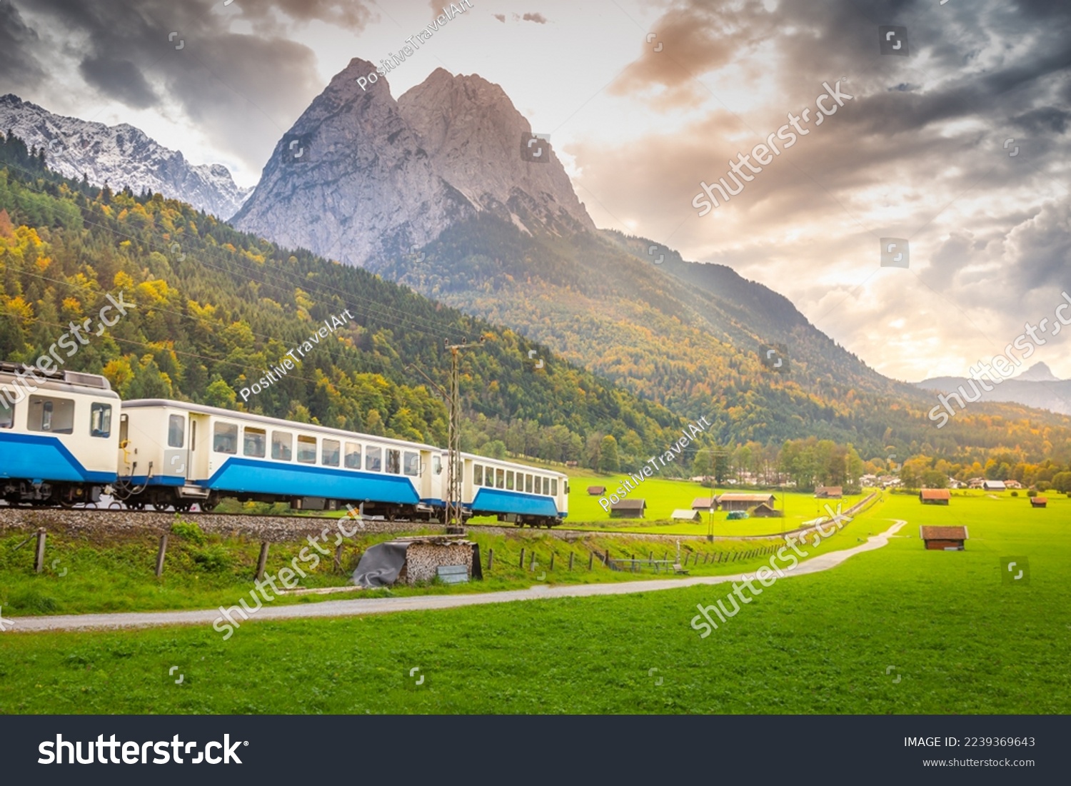 Train in Bavarian alps at autumn and wooden barns at sunset, Garmisch, Germany #2239369643