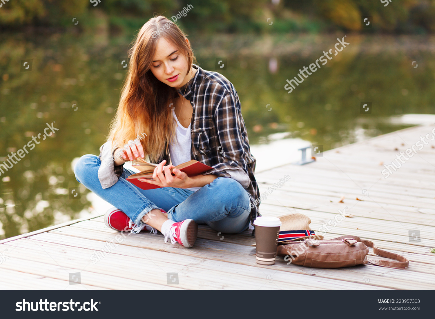 Young beautiful girl sitting on a pier #223957303