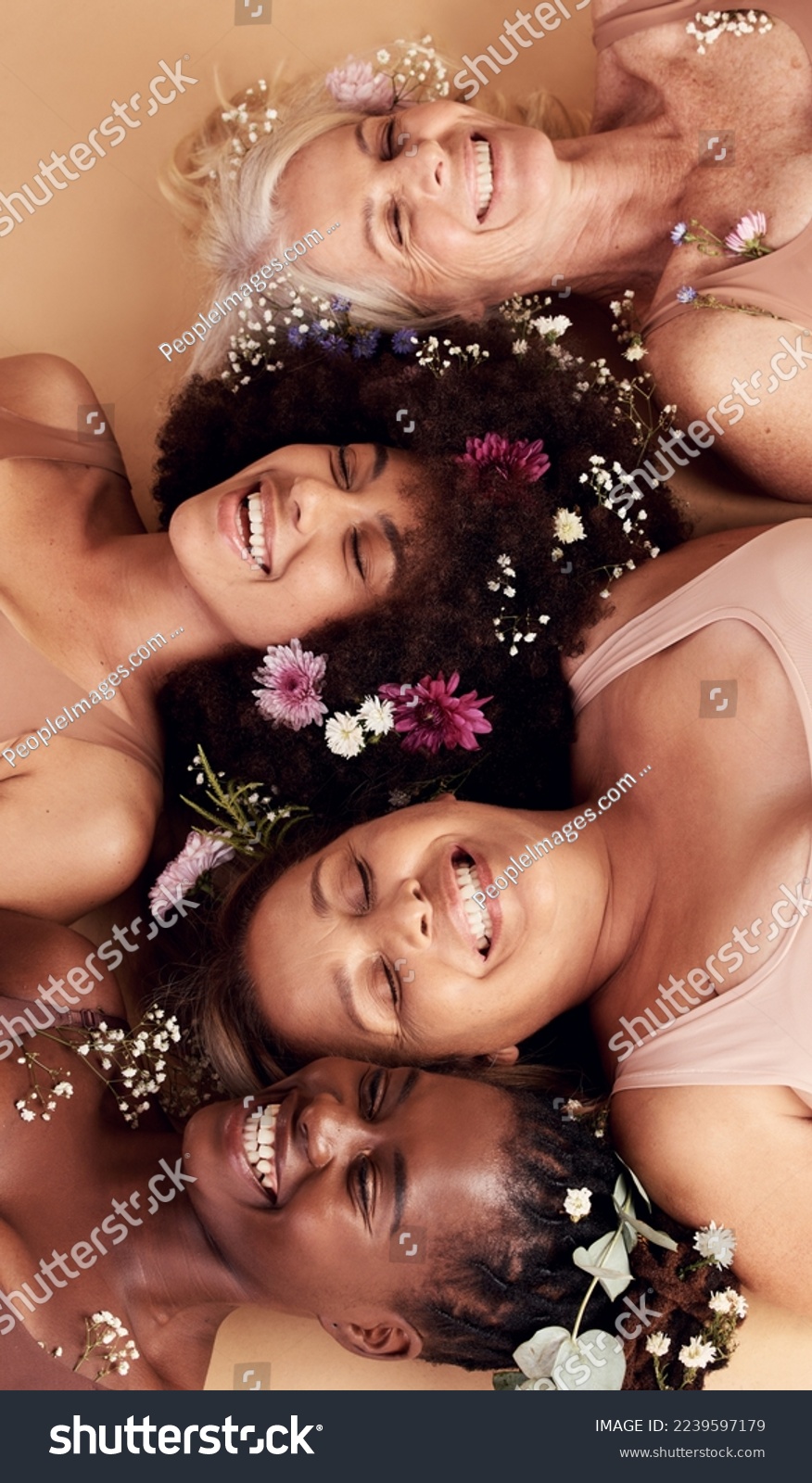 Top view, women diversity or faces with flowers on studio background in empowerment, divine feminine energy or self love. Smile, happy or skincare beauty models with plants, leaf or organic spa glow #2239597179