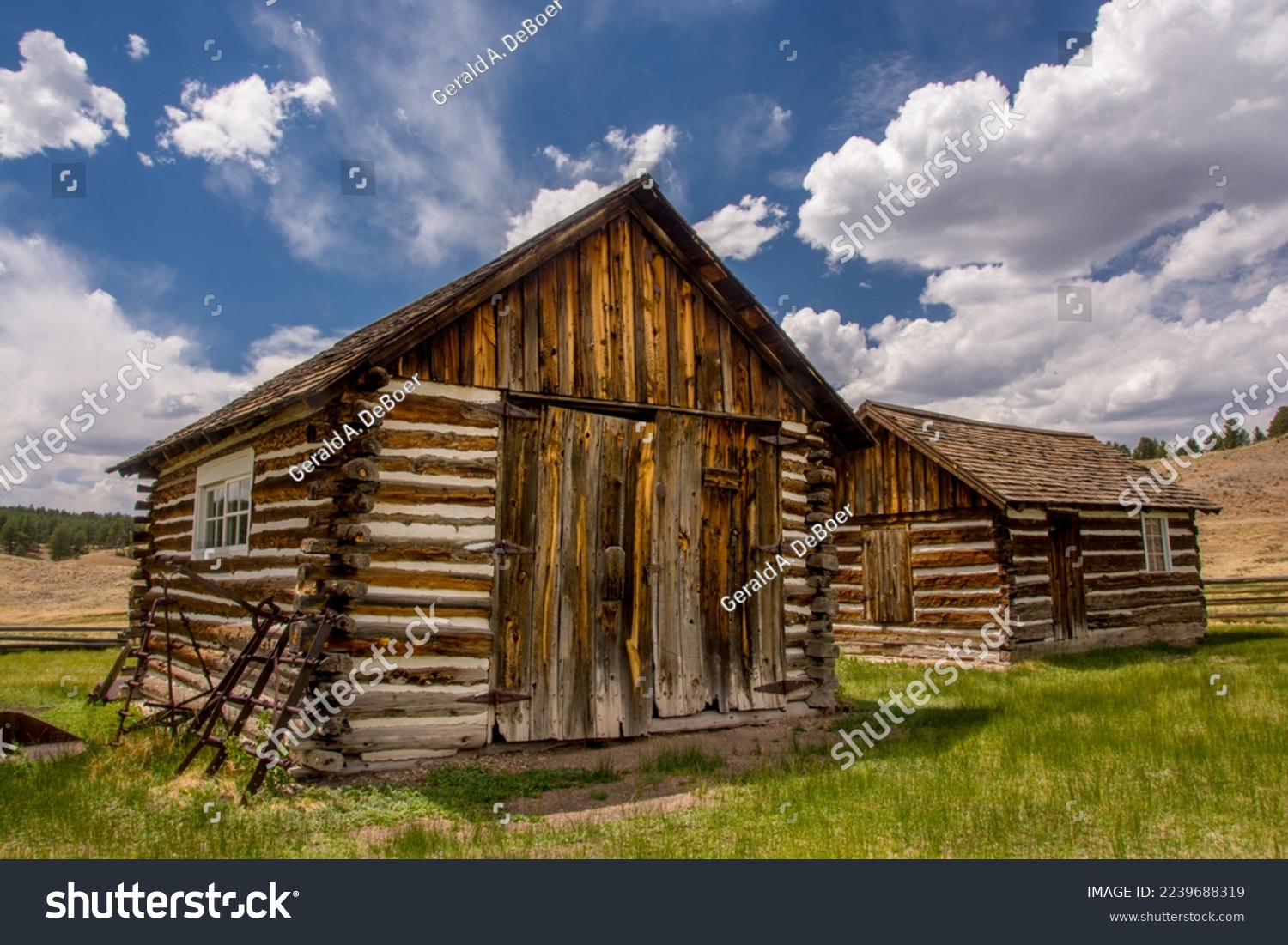 Some old log cabins standing beneath a beautiful summer sky in the Colorado high country. #2239688319