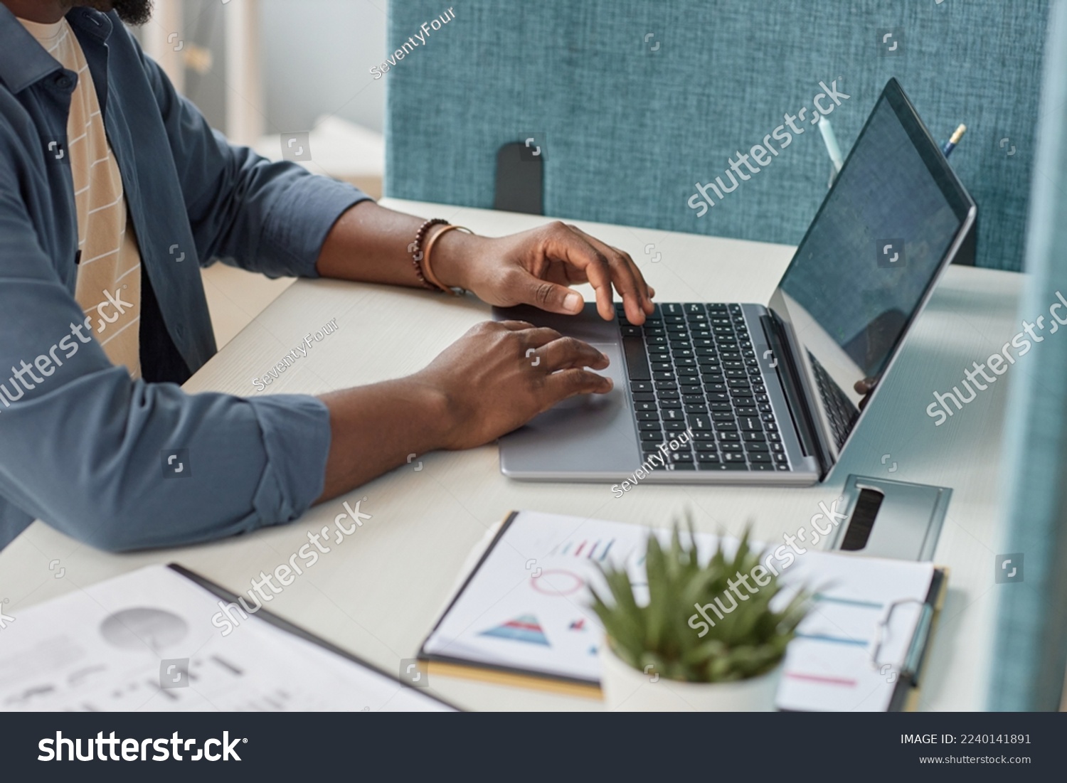 Close up of unrecognizable black man typing at laptop keyboard while using laptop at workplace, copy space #2240141891