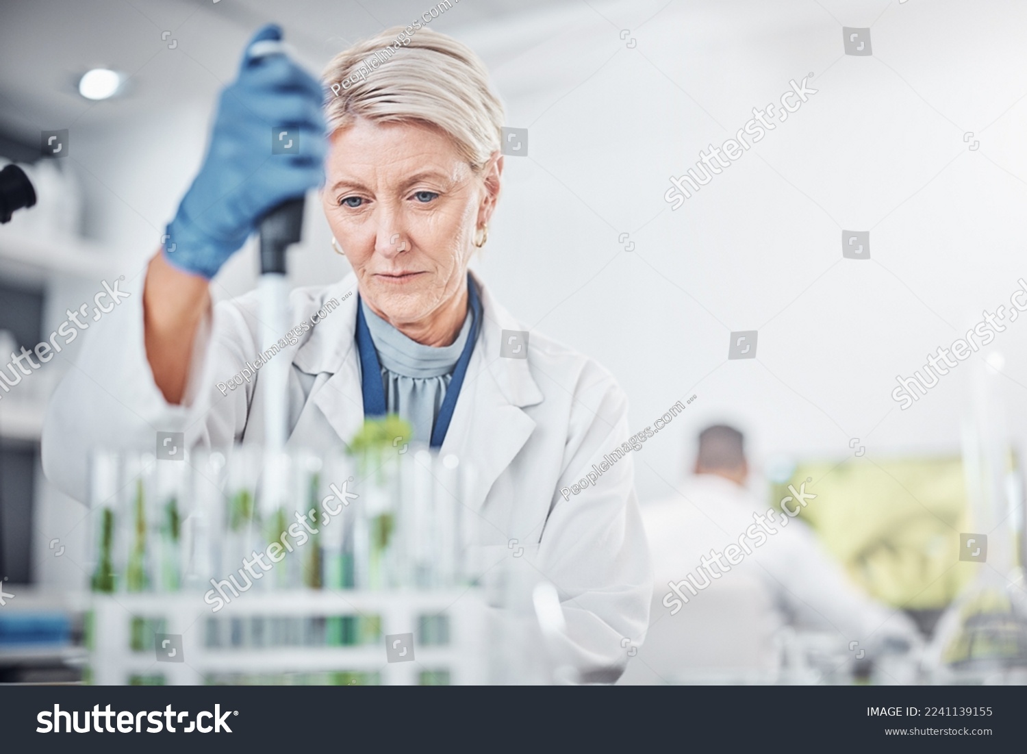 Scientist woman, laboratory and test tube with plants, research and analysis of leaves for ecology. Senior science expert, glass and health study of plant for pharma, medicine or sustainable medicine #2241139155