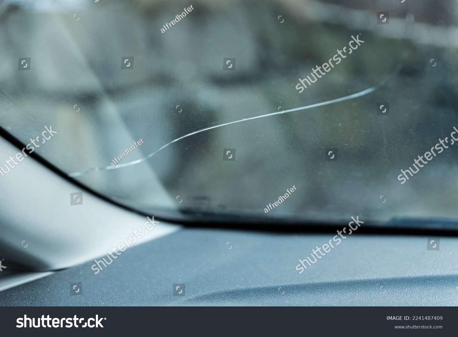 Defective windshield from falling rocks - crack in the safety glass #2241487409