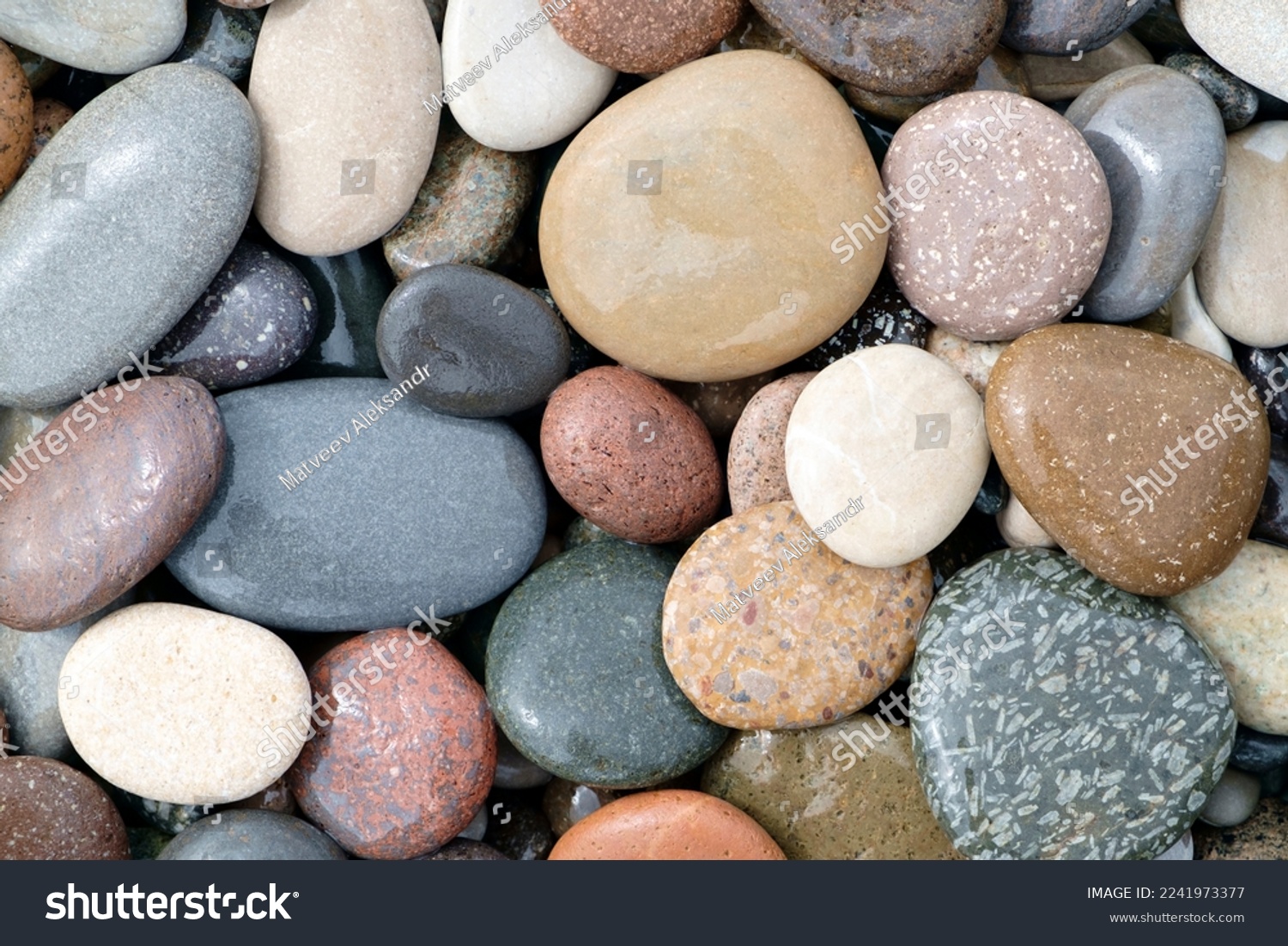 Smooth round wet pebbles texture background. Pebble sea beach close-up #2241973377