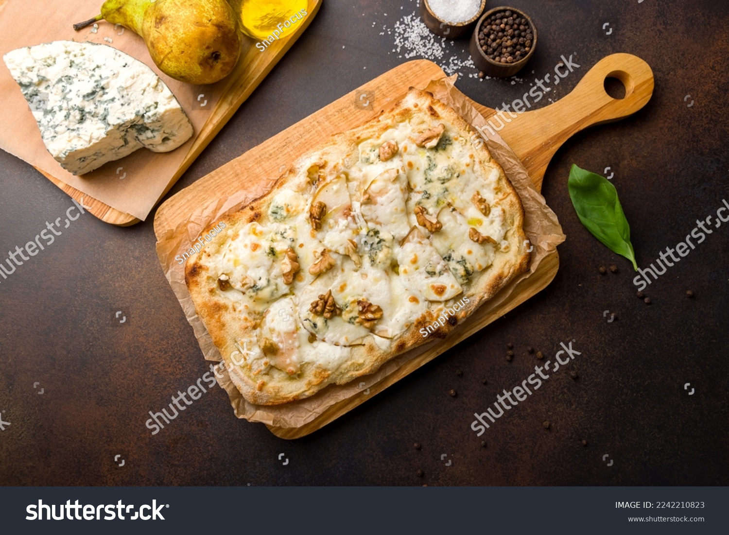 pizza with pear and Gorgonzola on Roman dough, pinsa on dark brown table top view #2242210823