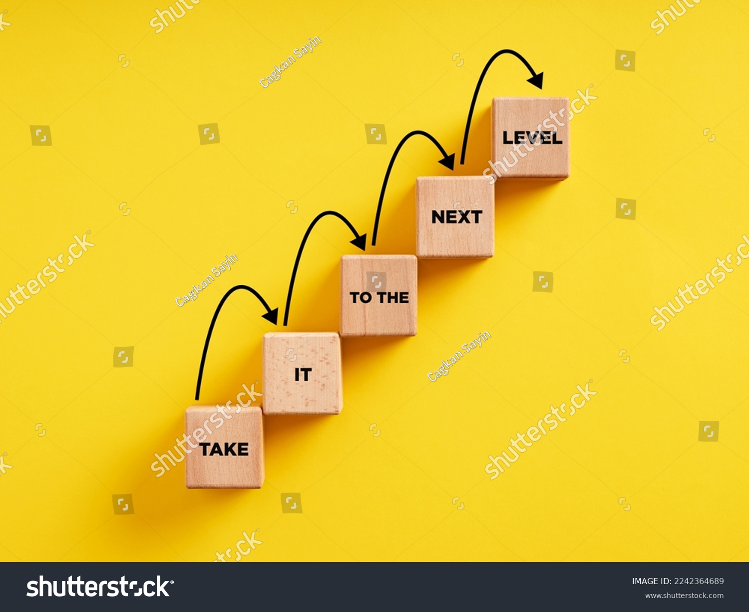 Business career path for growth and success concept. Wooden block ladder with the message take it to the next level with stepping up arrows. #2242364689