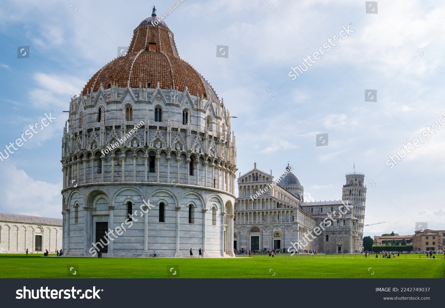 Leaning tower of Pisa Italy with Basilica Cathedral on a bright summer day with green grass low angle.  #2242749037