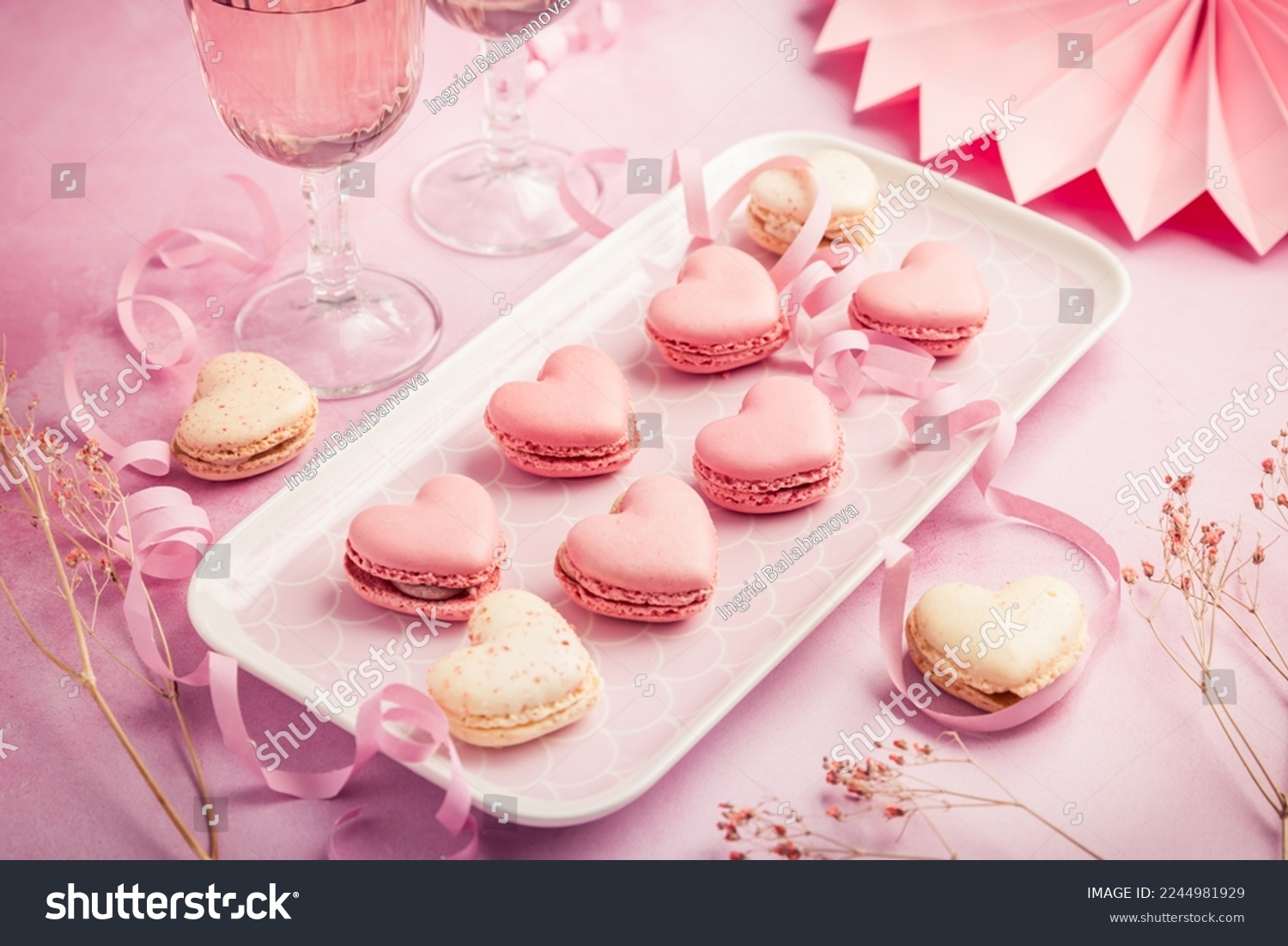Happy Mothers Day, Happy Valentine - sweet macarons in heart shape and glasses of rose sparkling wine in pink tone #2244981929
