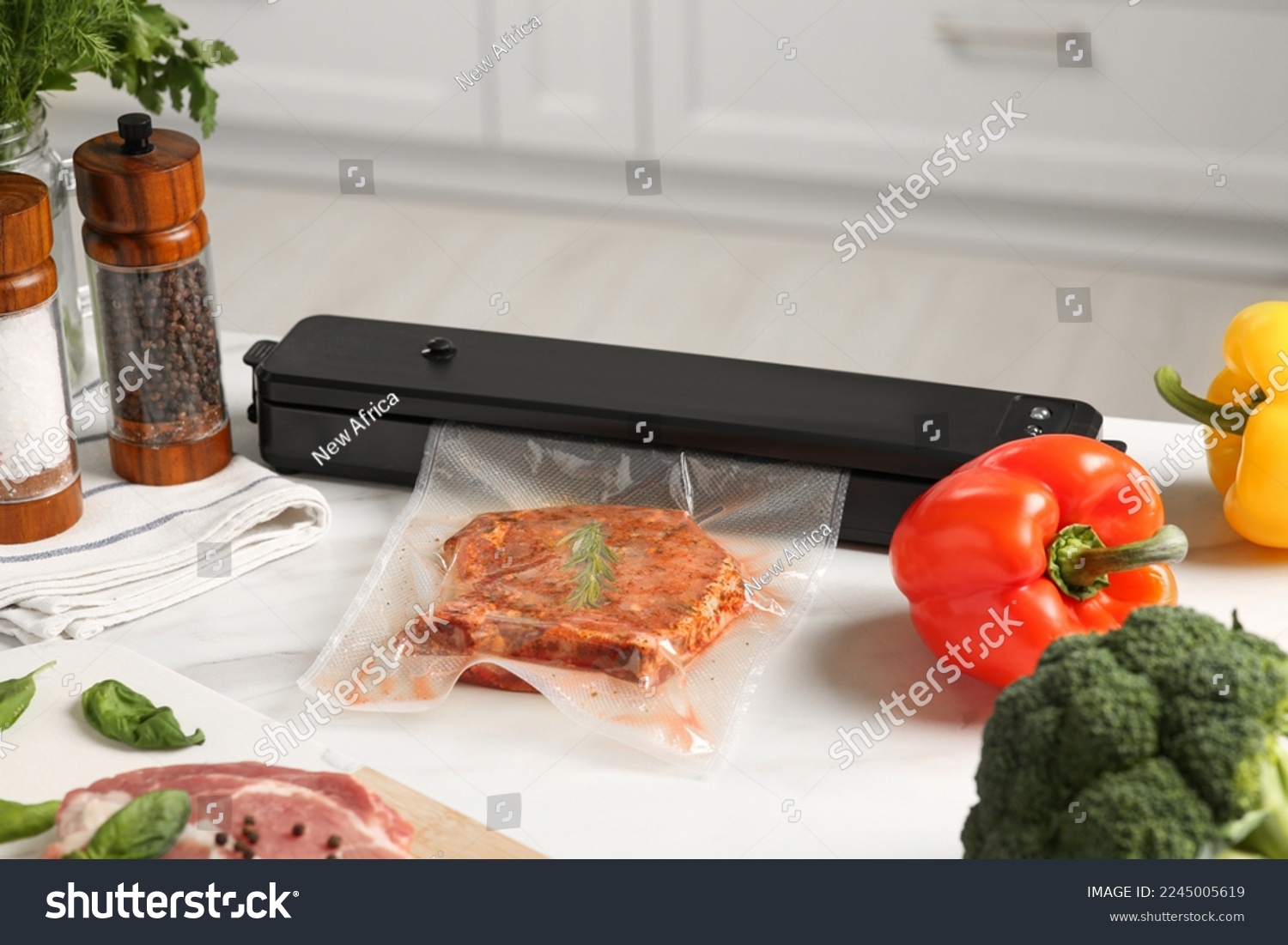 Sealer for vacuum packing with meat in plastic bag on white kitchen table #2245005619