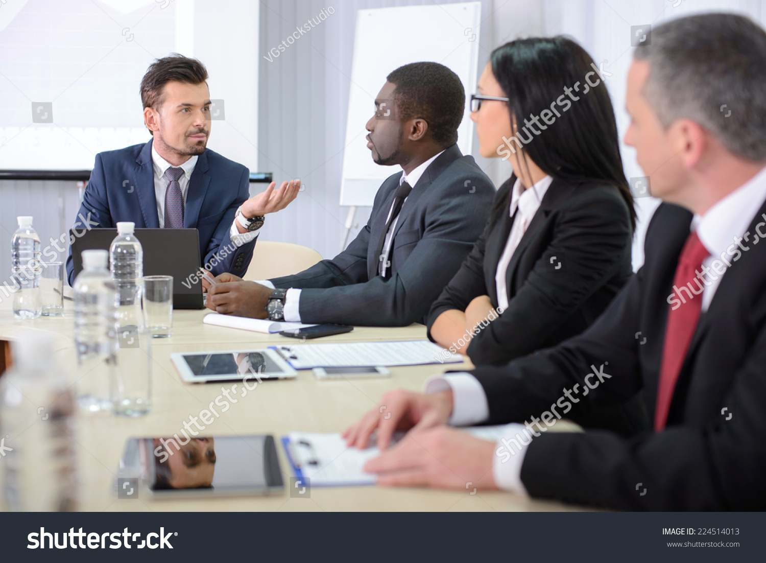 Business conference. Business meeting. Business people in formalwear discussing something while sitting together at the table #224514013