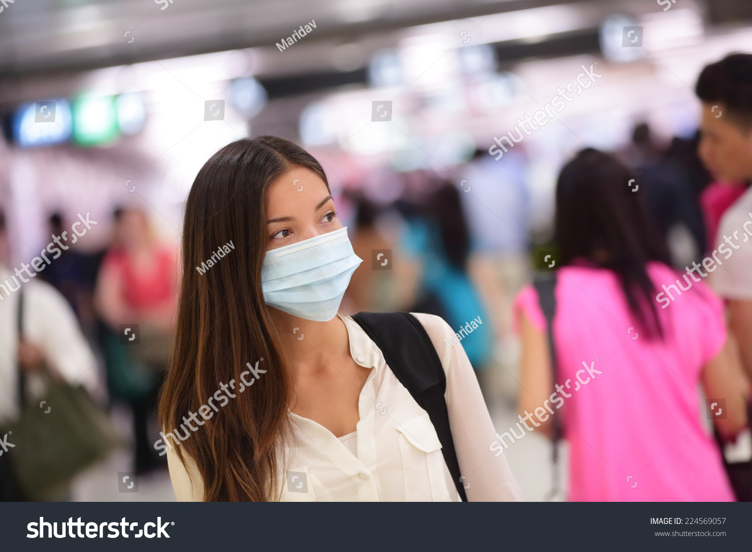 Asian woman wearing surgical face mask against infectious disease protection against cold common flu. Young tourist commuter girl walking in  airport public area. #224569057