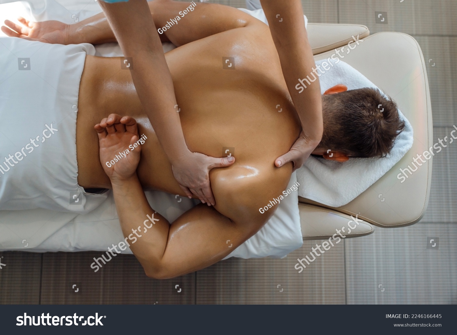 Sports man massage in a light room, procedure in a fitness center #2246166445