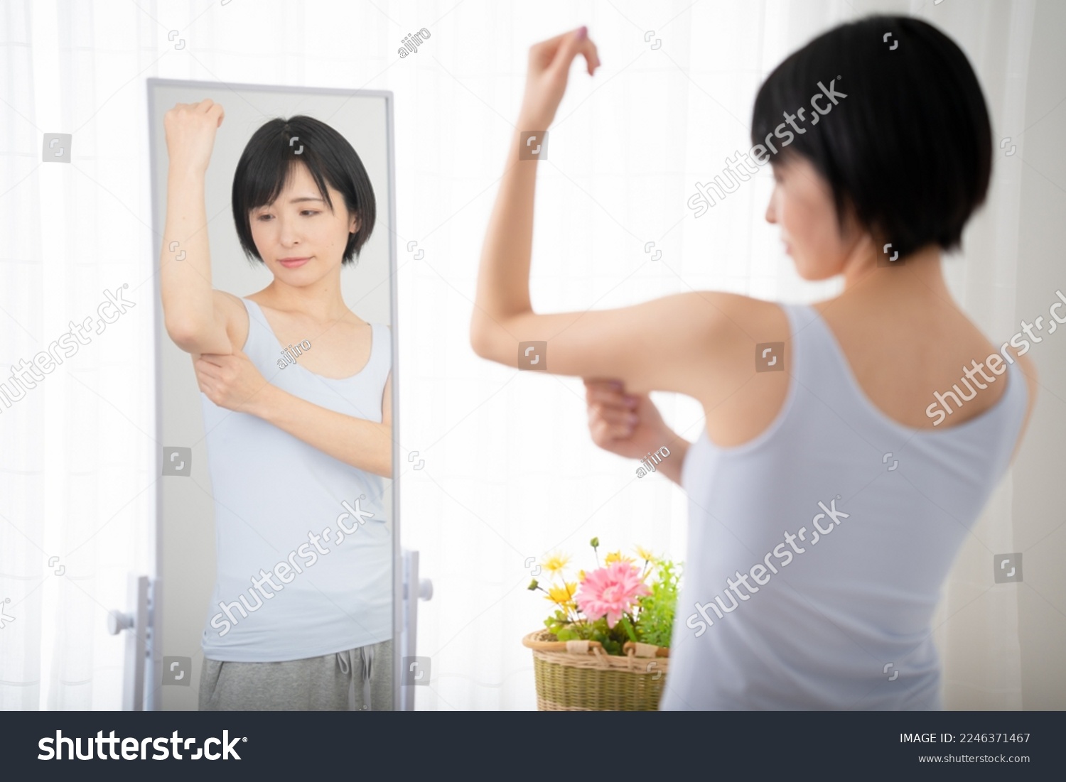 Diet image of a young woman checking her upper arm in the mirror #2246371467