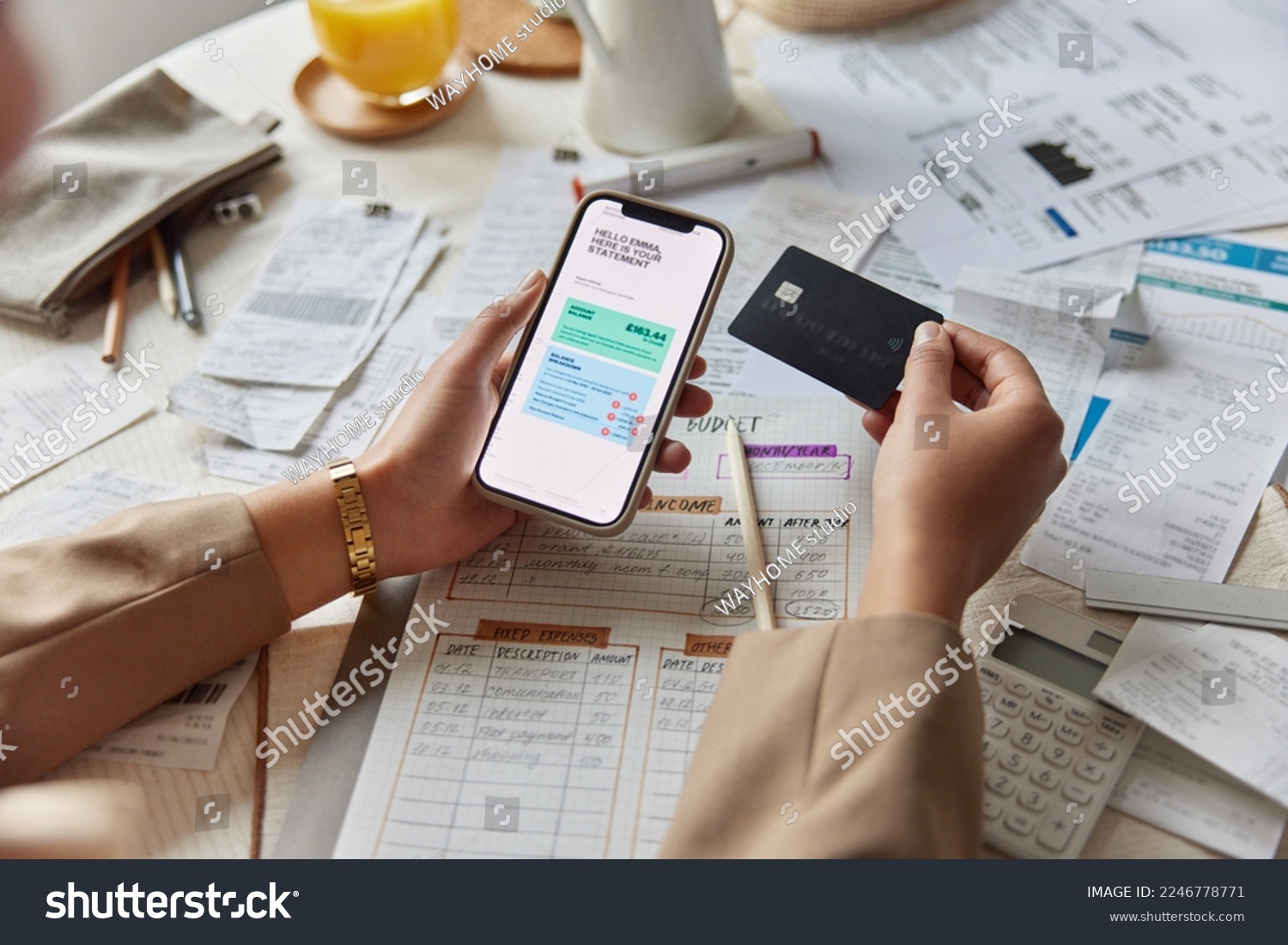 Close up shot of woman sits at table works with financial documents holds smartphone banking card manages family budget calculates expenses makes payment plans investment leads accounting of company #2246778771