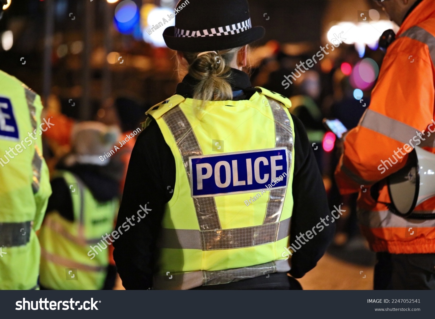 Police officer in hi-visibility jacket policing crowd control at an outside UK event #2247052541