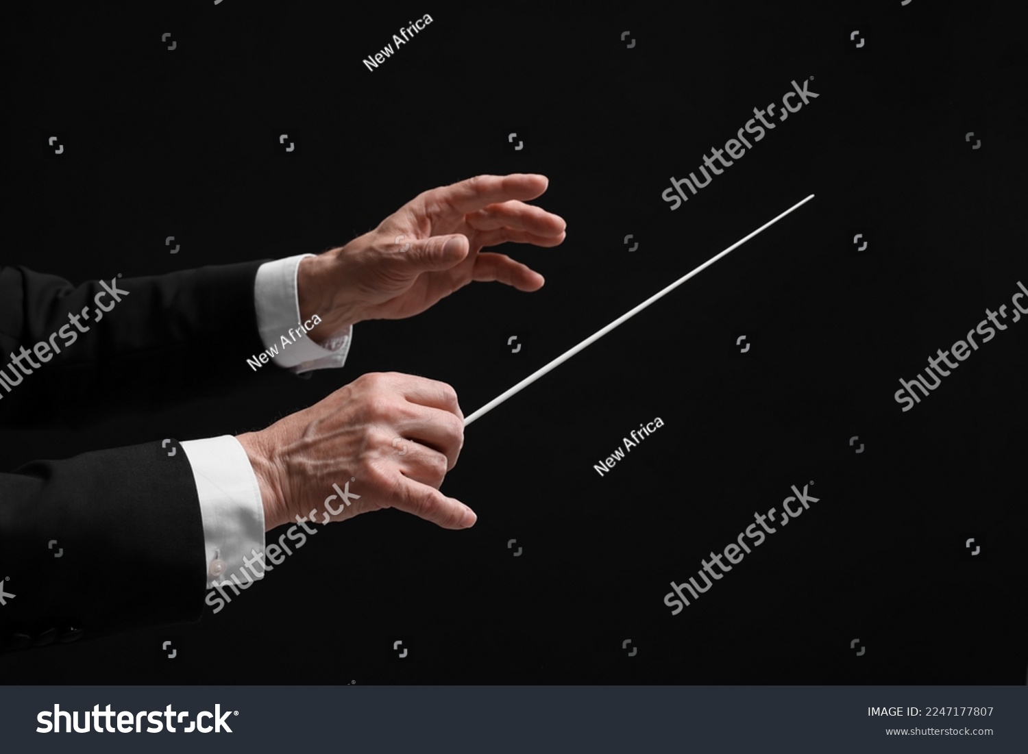 Professional conductor with baton on black background, closeup #2247177807