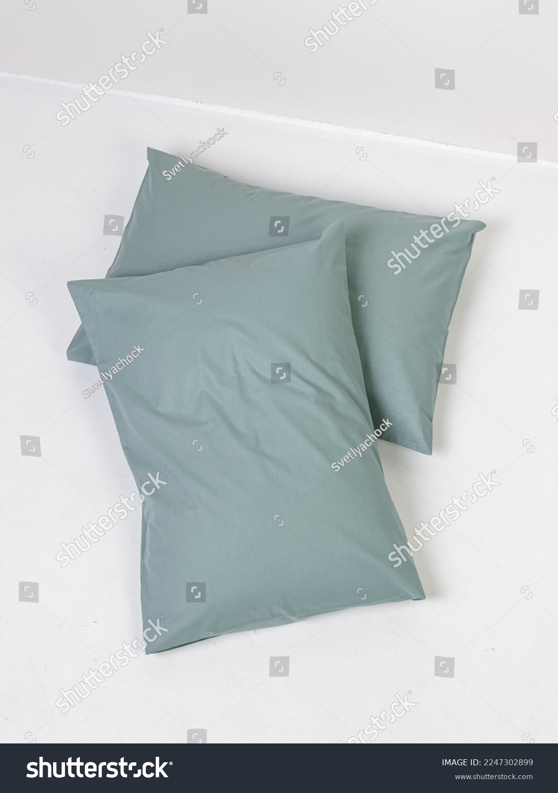 Two pillows in green pillowcases on white background #2247302899
