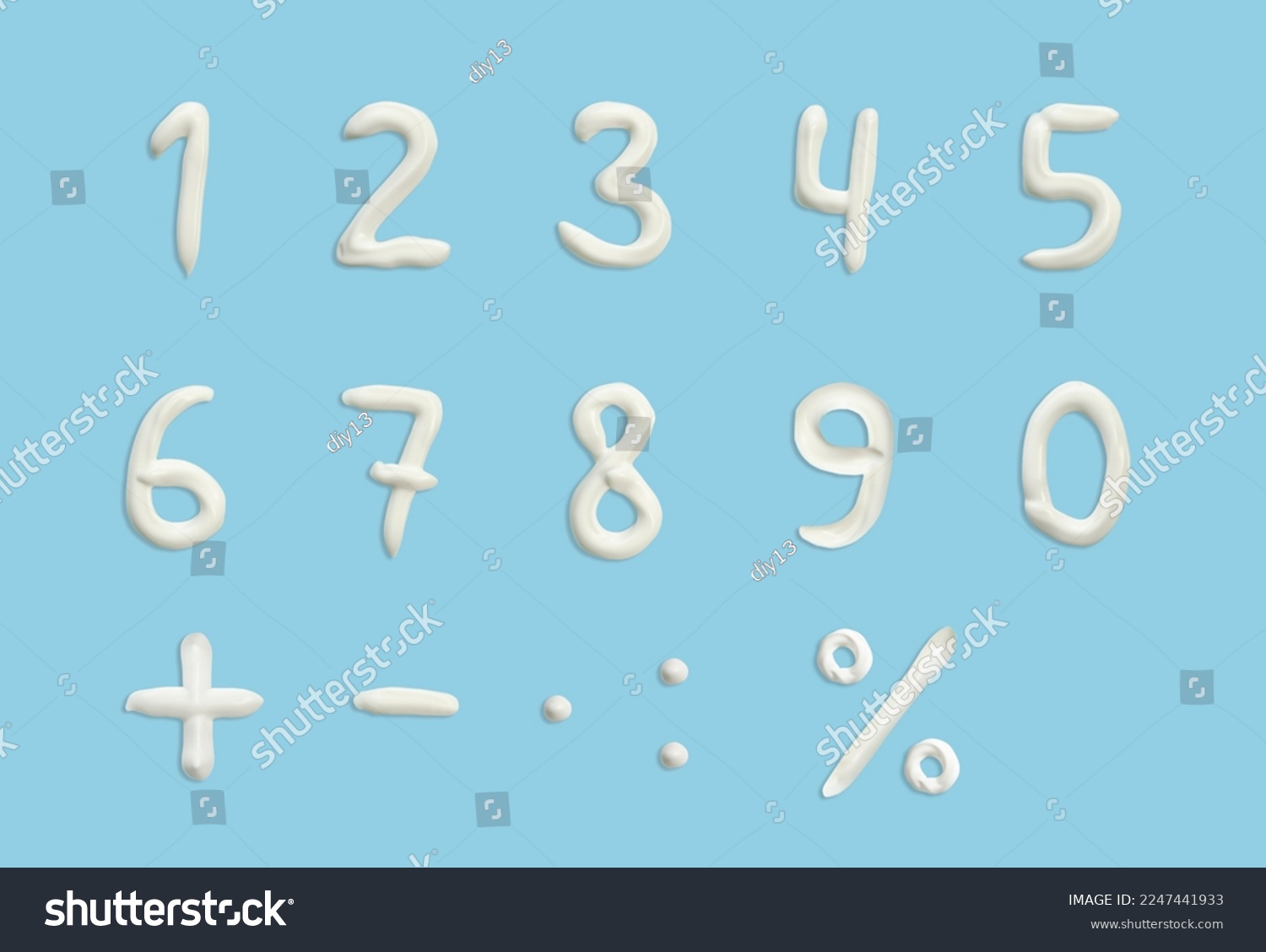 numbers of English alphabet in the form of squeezed cream in white on a blue background. #2247441933