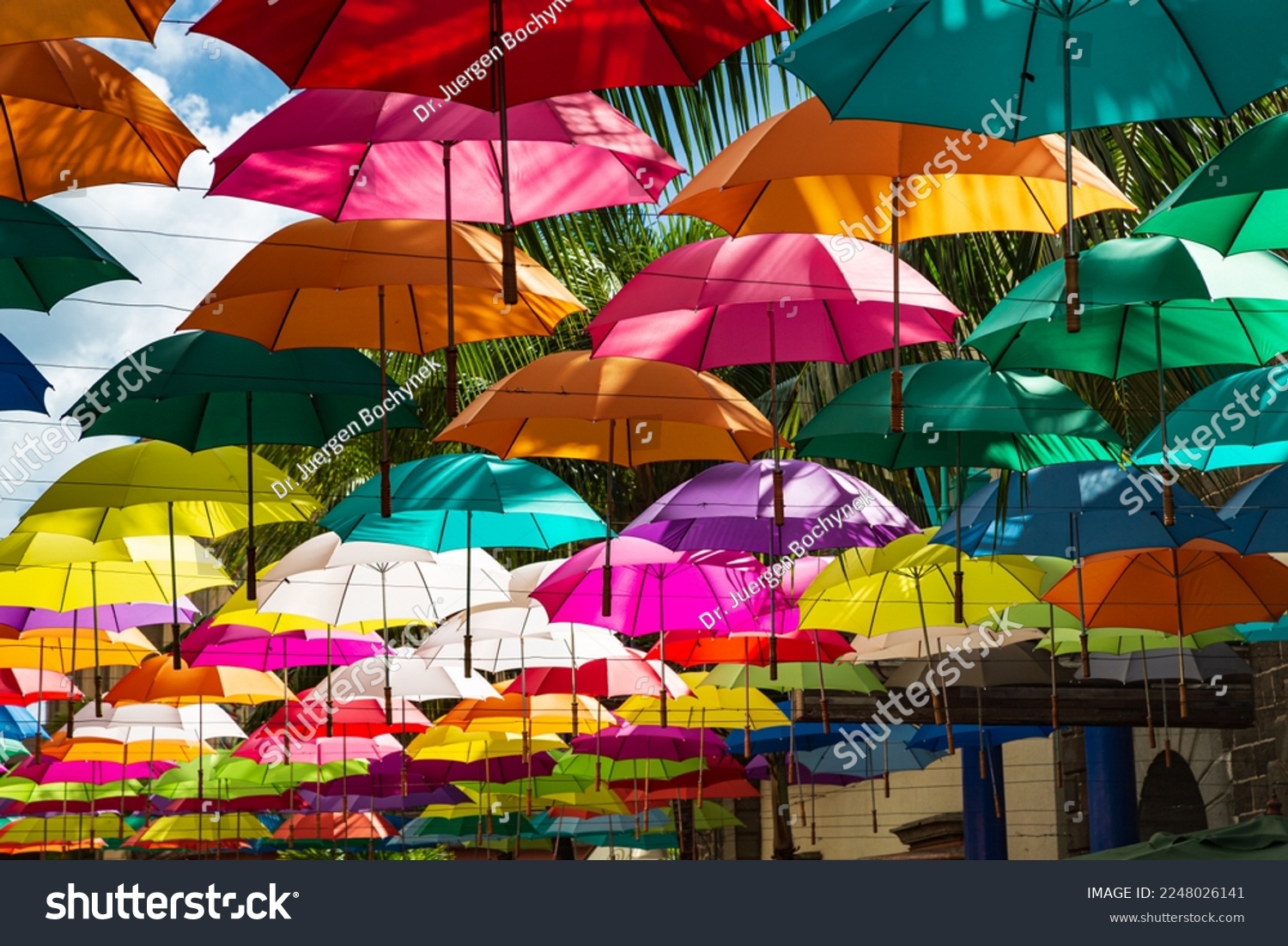 Colorful umbrellas spanning street at Caudan Waterfront shopping center, Port Louis, Mauritius #2248026141