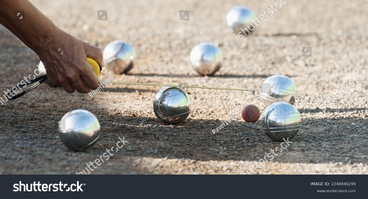 Petanque game, woman measuring the distance of petanque ball in petanque field, deciding who's the winner #2248946299