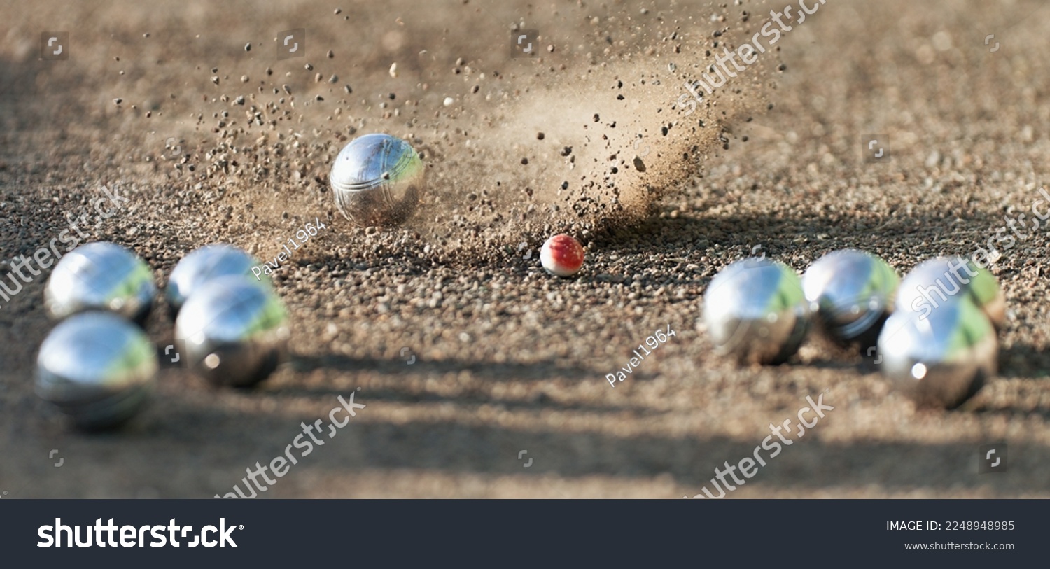 Petanque ball boules bowls on a dust floor, photo in impact. Game of petanque on the ground. Balls and a small wood jack #2248948985