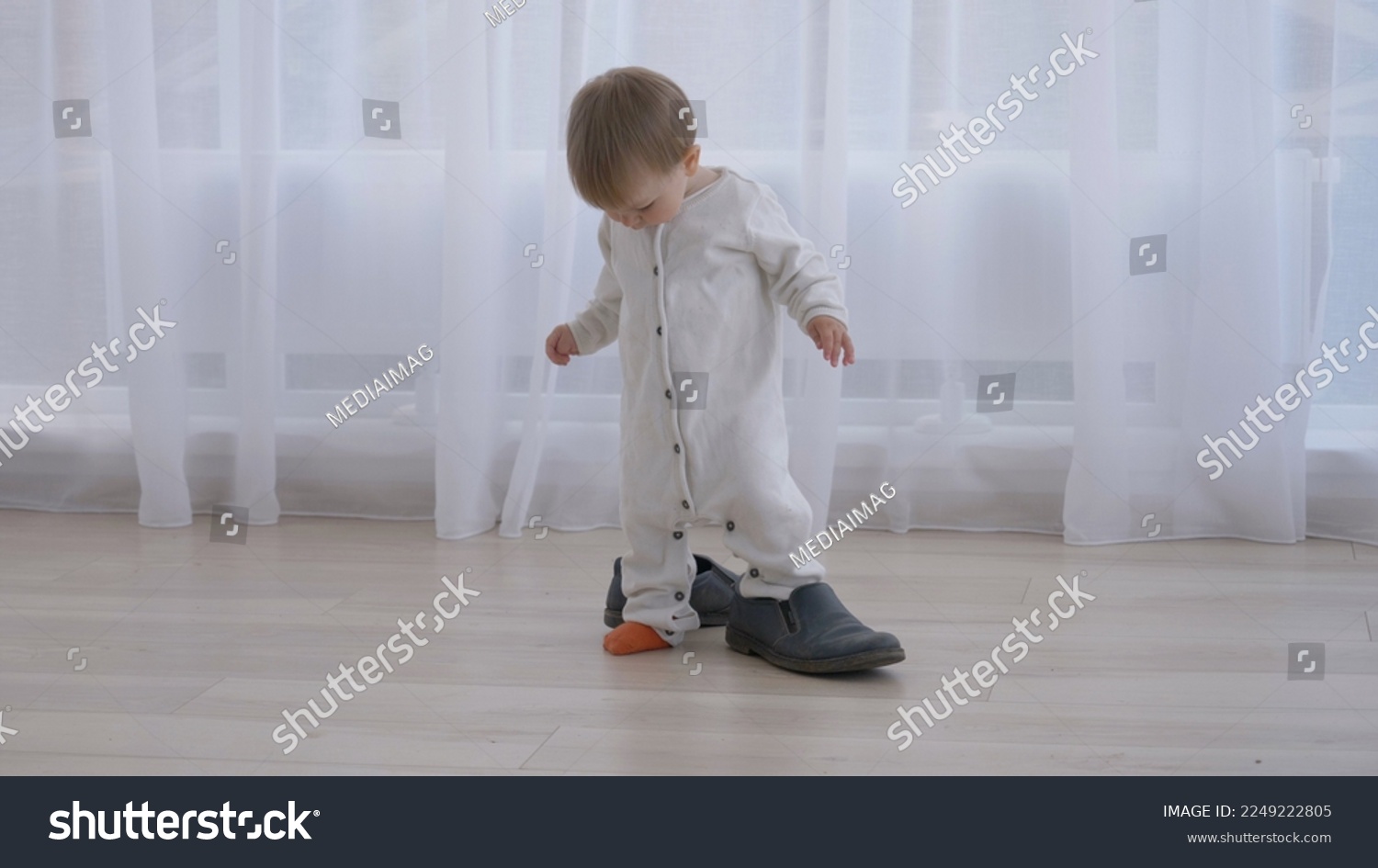 Little baby trying to wear daddy's big shoes #2249222805