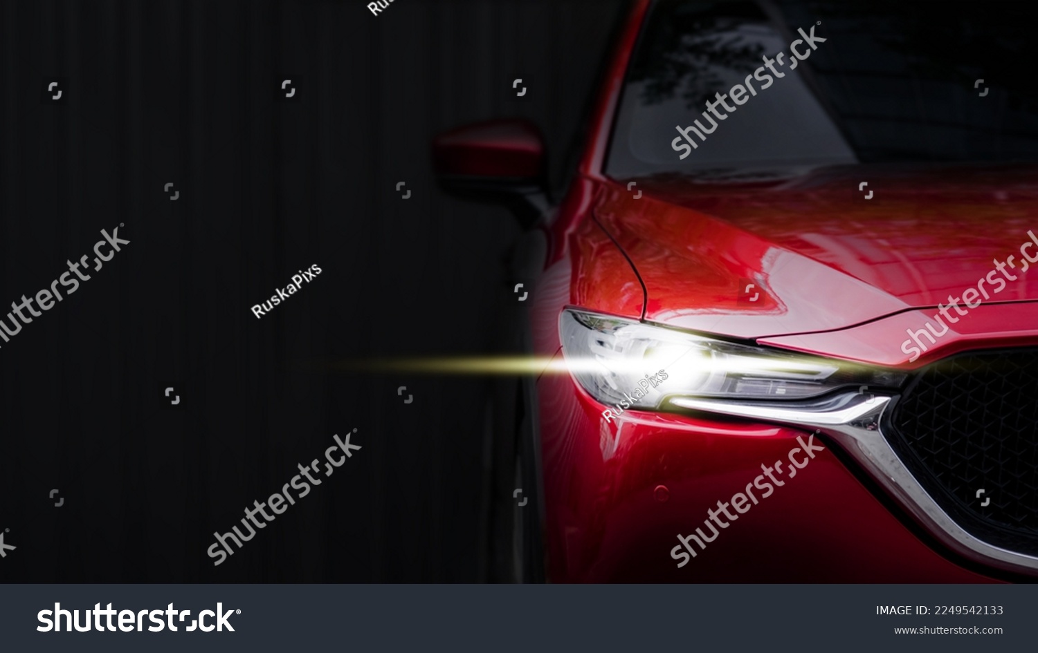 close up headlight of red car against black background. #2249542133