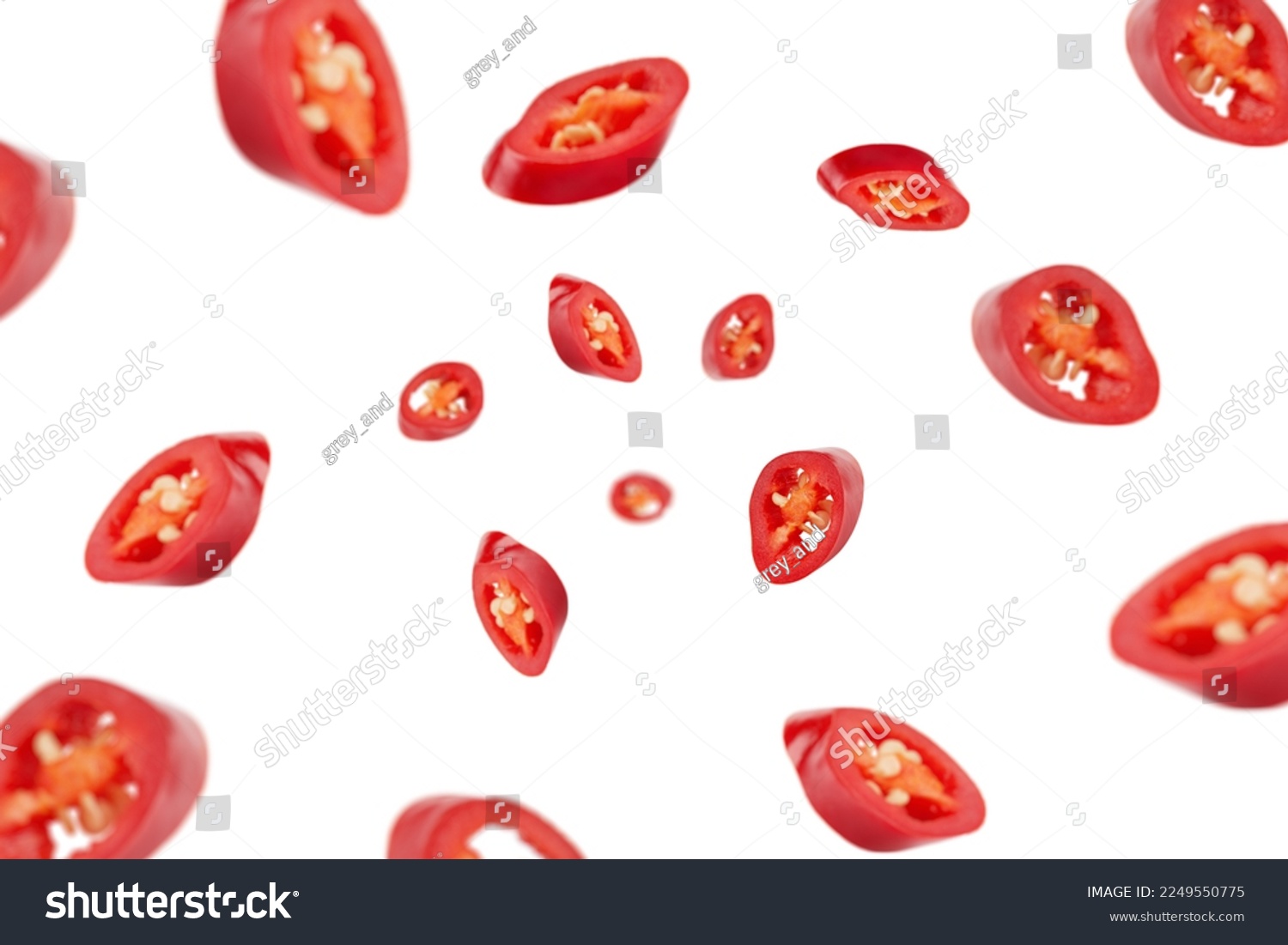 Falling sliced red hot chili peppers isolated on white background, selective focus #2249550775