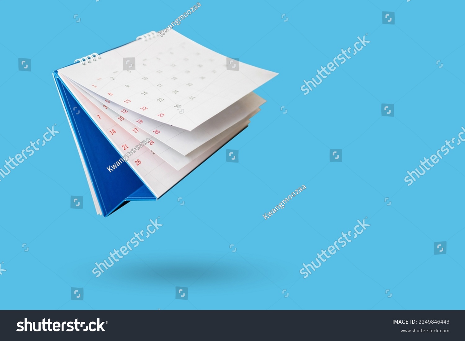White paper desk calendar flipping page isolated on blue background #2249846443